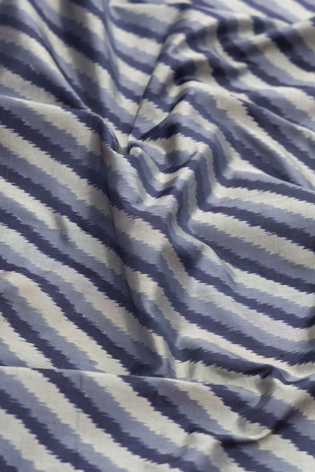 Close up of Grey Dual Tone Double Ikat Saree with Ikat Print on the body and Ikat Border.  displaying folds