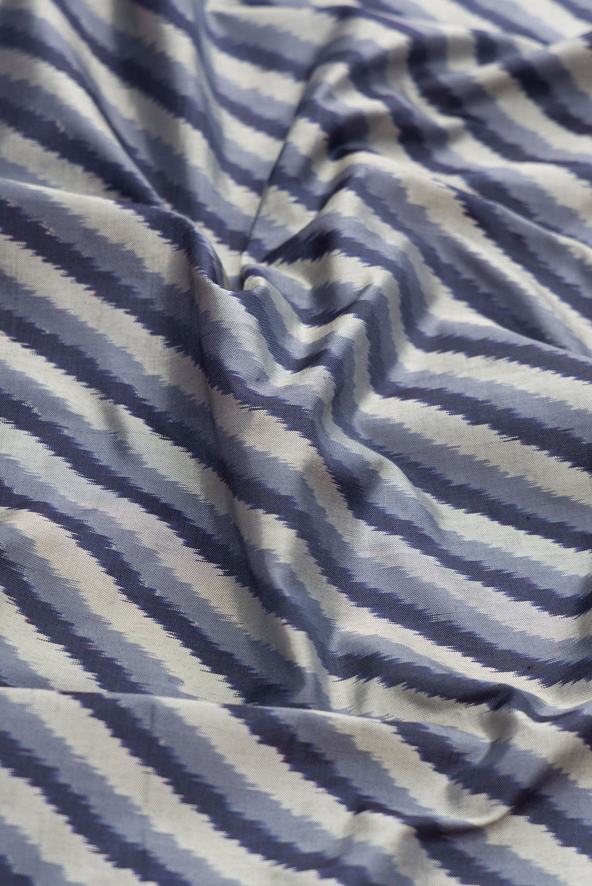 Close up of Grey Dual Tone Double Ikat Saree with Ikat Print on the body and Ikat Border.  displaying folds