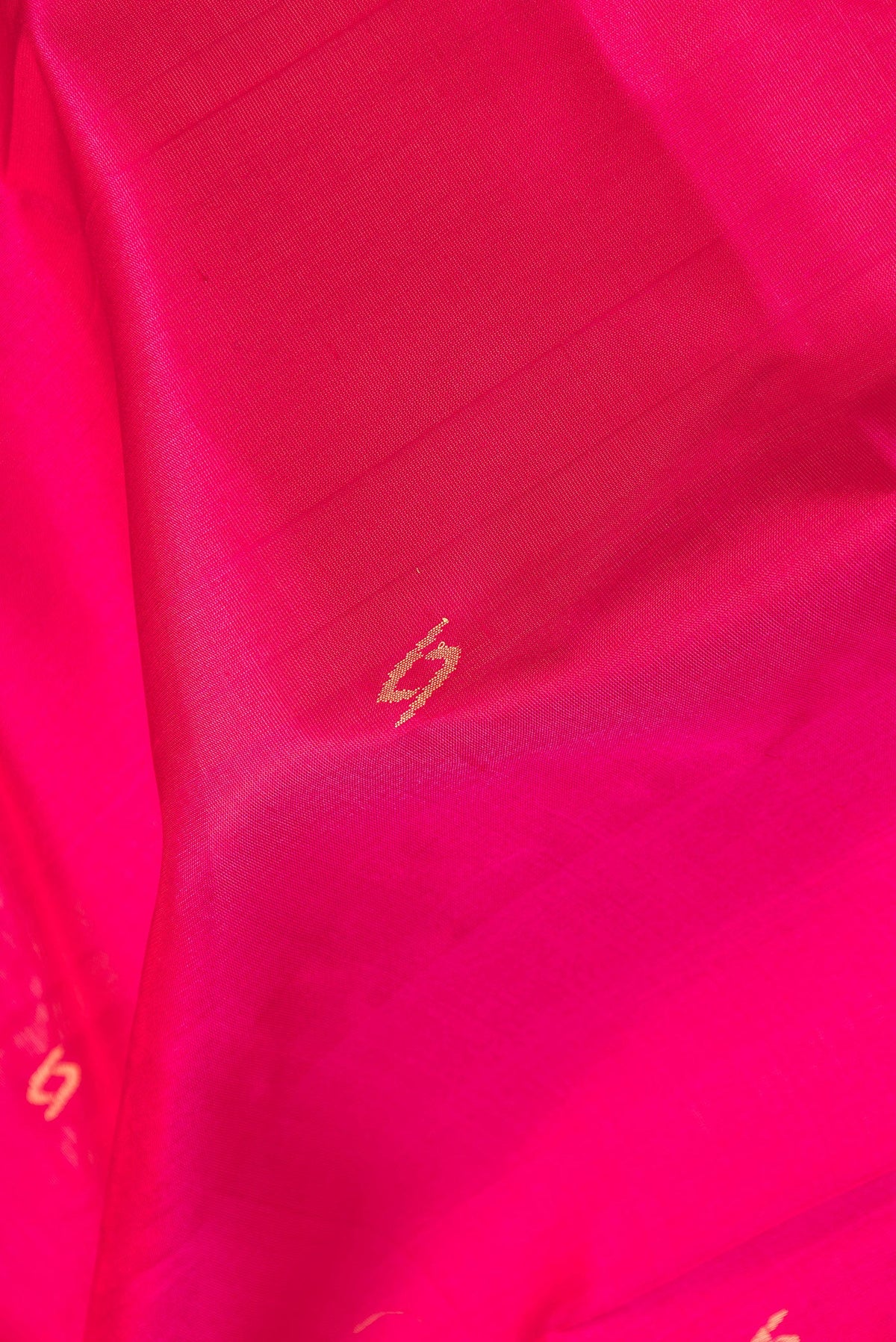 Close up of Pink Dual Tone Uppada Silk Saree with Zari Butta on the body and Zari Border.  displaying folds