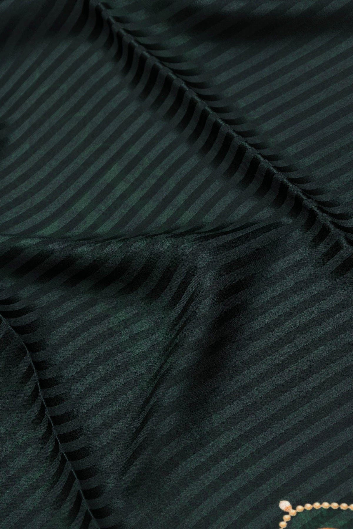 Close up of Bottle Green Dual Tone Mysore Crepe Saree with Printed design on the body and Printed Border.  displaying folds