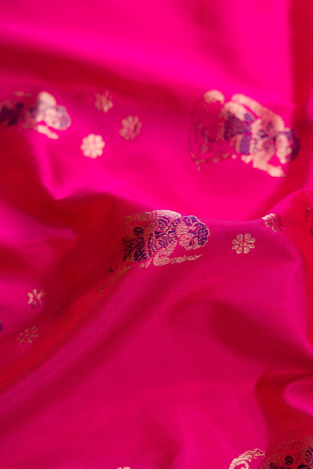 Close up of Pink Baluchari Silk Saree with Zari And Thread Butta on the body and Zari Border.  displaying folds