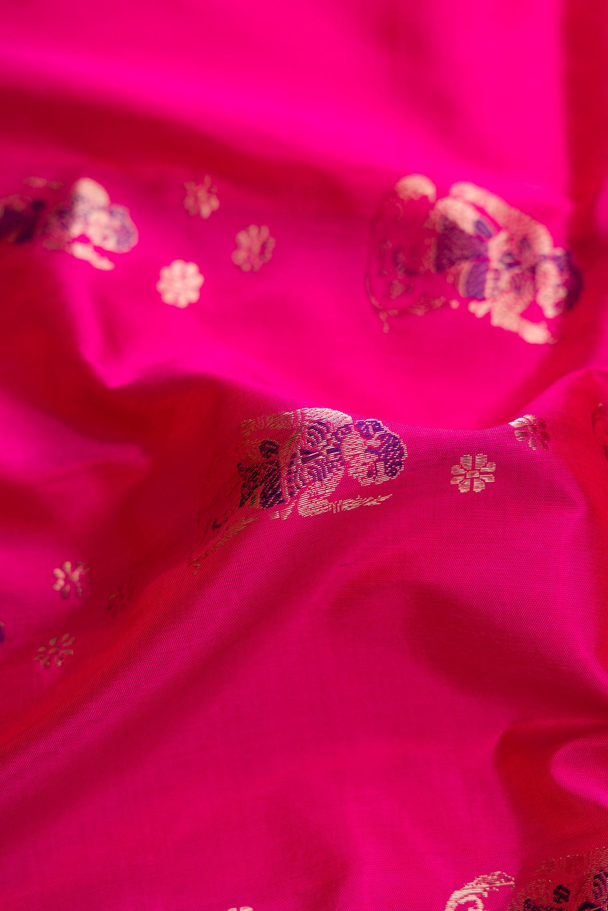 Close up of Pink Baluchari Silk Saree with Zari And Thread Butta on the body and Zari Border.  displaying folds