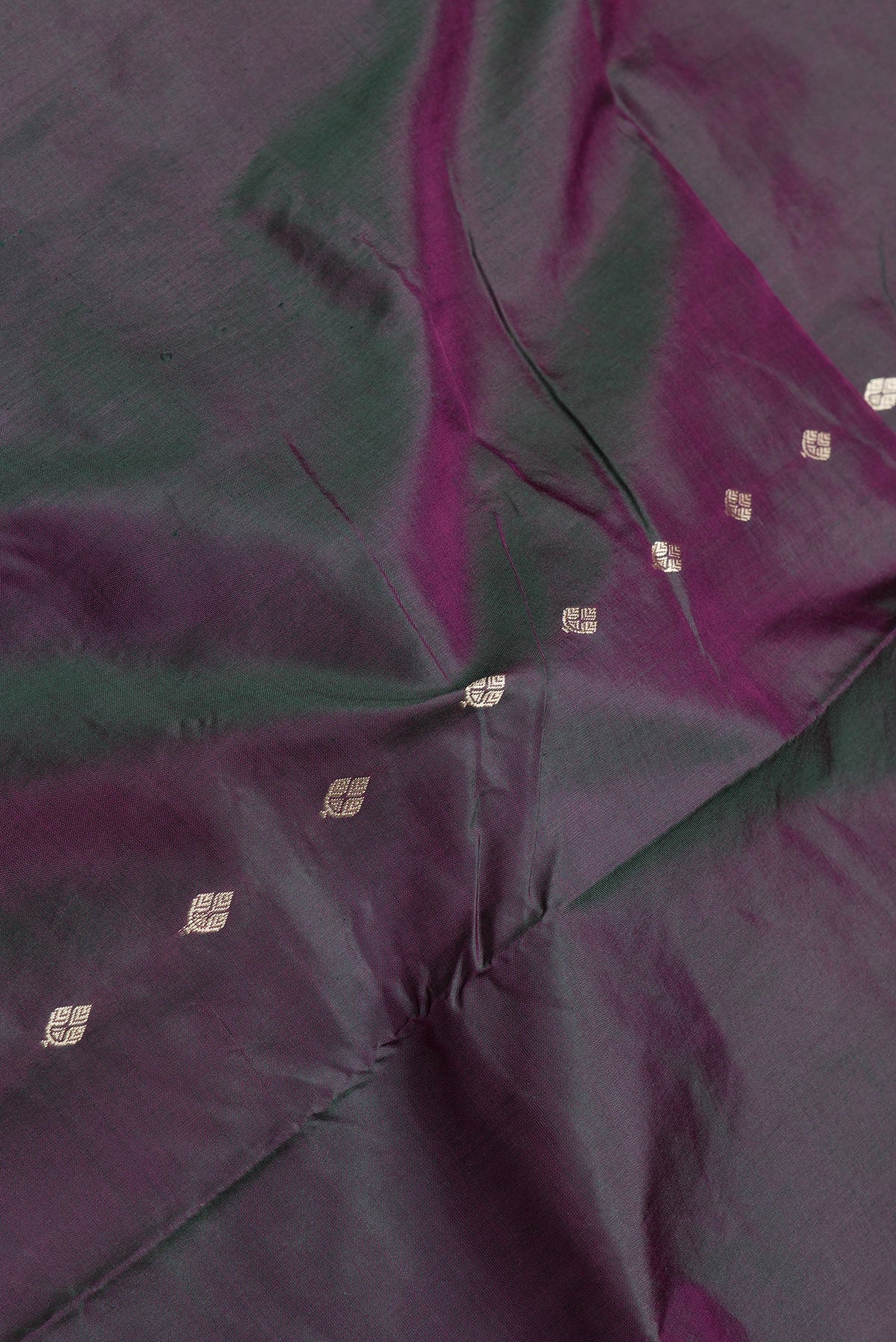 Close up of Green Dual Tone Banarasi Silk Saree with Thread Butta on the body and Thread Border.  displaying folds
