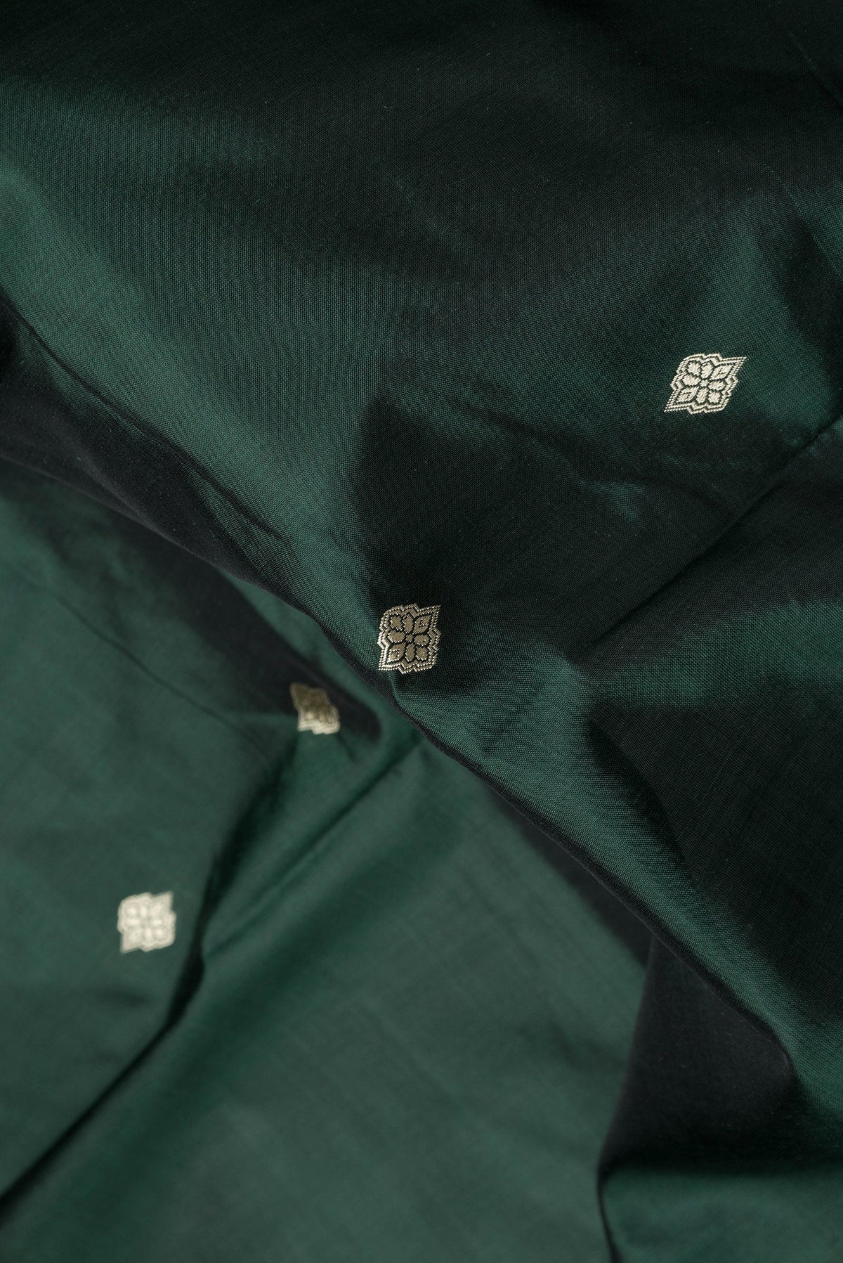 Close up of Bottle Green Dual Tone Banarasi Silk Saree with Thread Butta on the body and Thread Border.  displaying folds