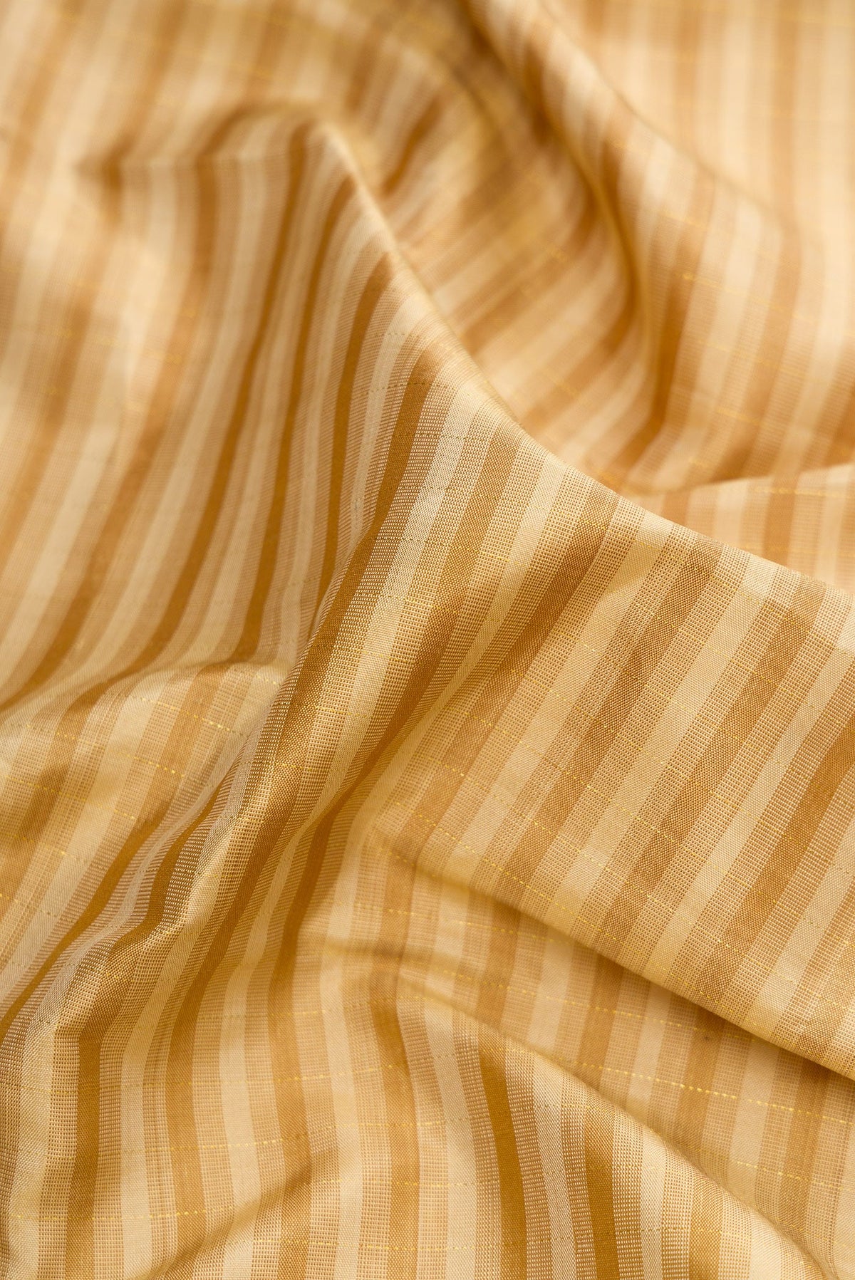 Close up of Dark Beige Dual Tone Kanchipuram Silk Saree with Checked design on the body and Zari Border.  displaying folds