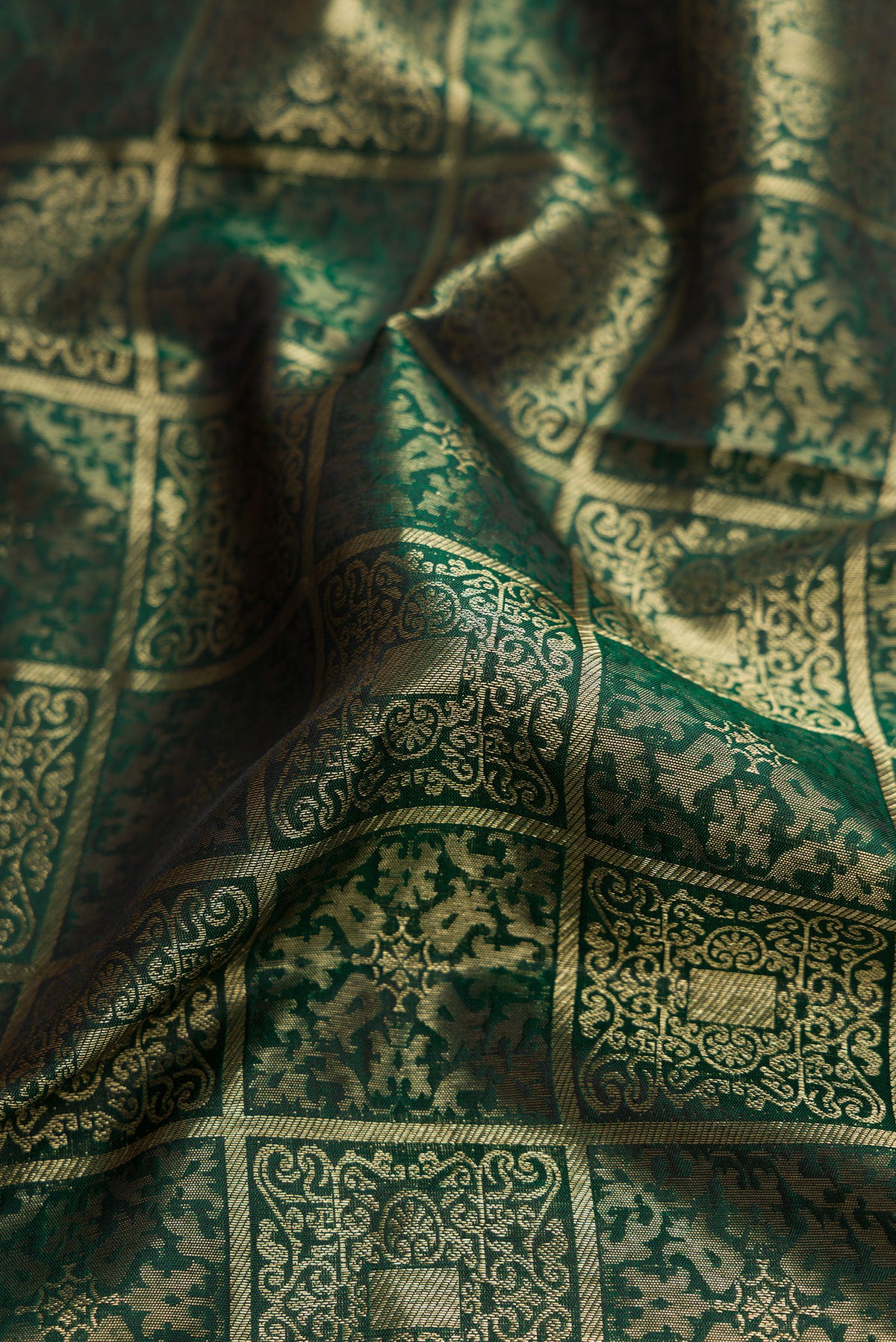 Close up of Bottle Green Kanjivaram Silk Saree with Zari Brocade on the body and Zari Border.  displaying folds