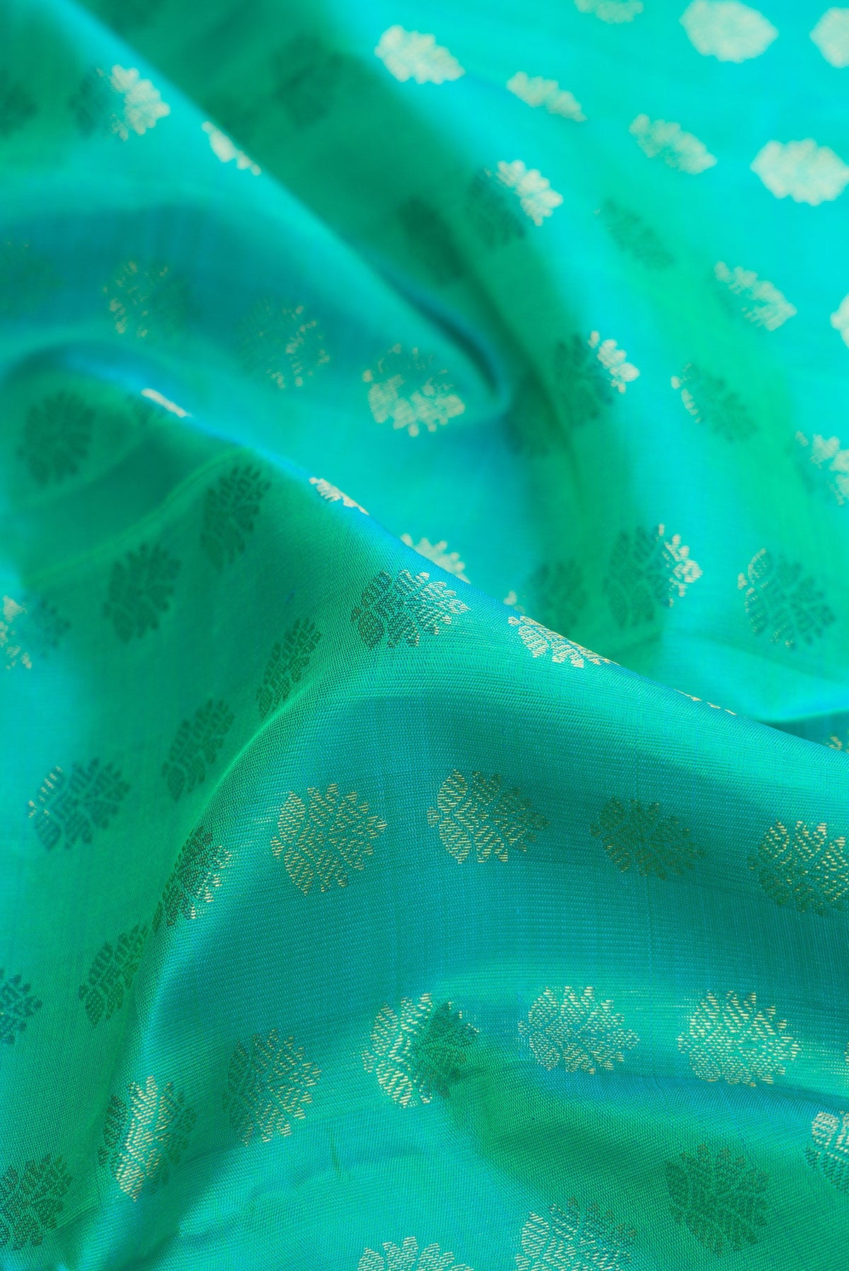Close up of Pure Silk Pure Zari Sea Green Dual Tone Kanjivaram Saree with Zari Butta on the body and Zari Border.  displaying folds