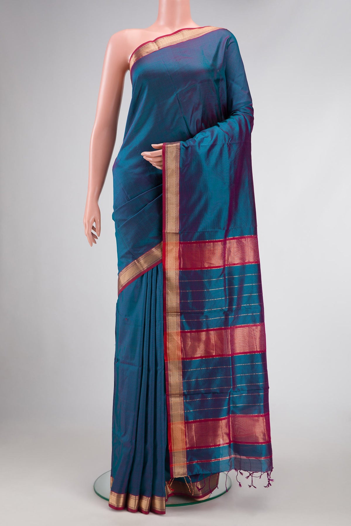 Peacock Blue Dual Tone Maheshwari Silk Saree with Stripes on the body and Zari Border.  displayed on a mannequin
