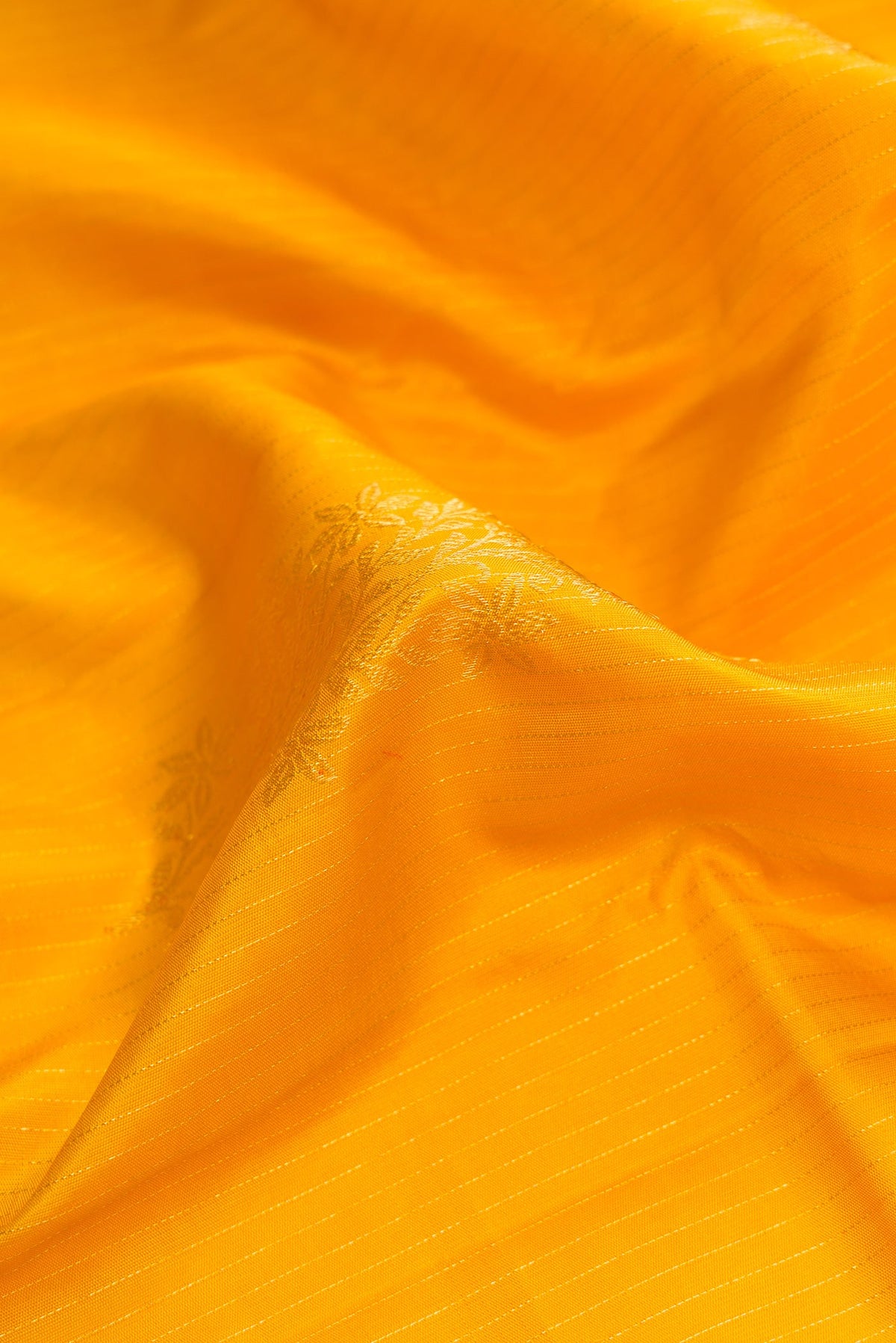Close up of Yellow Dual Tone Kanjivaram Silk Saree with Stripes on the body and Without Border.  displaying folds