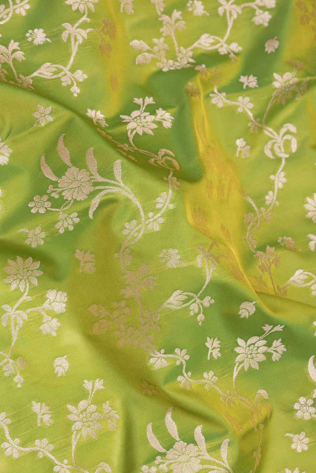 Close up of Parrot Green Dual Tone Blended Banarasi Saree with Zari Brocade on the body and Zari Border.  displaying folds