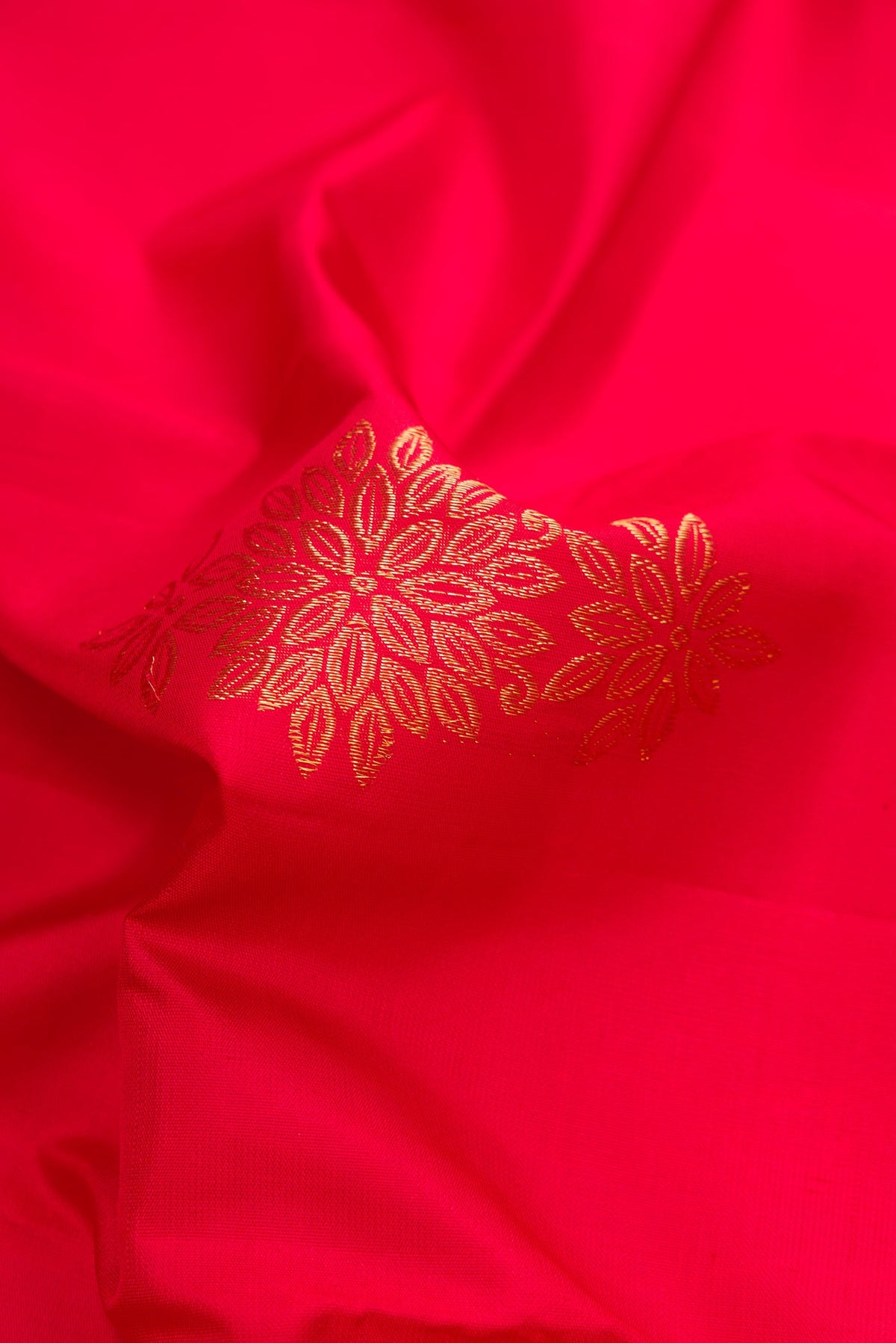 Close up of Red Dual Tone Kanjivaram Silk Saree with Zari Butta on the body and Fancy Border.  displaying folds