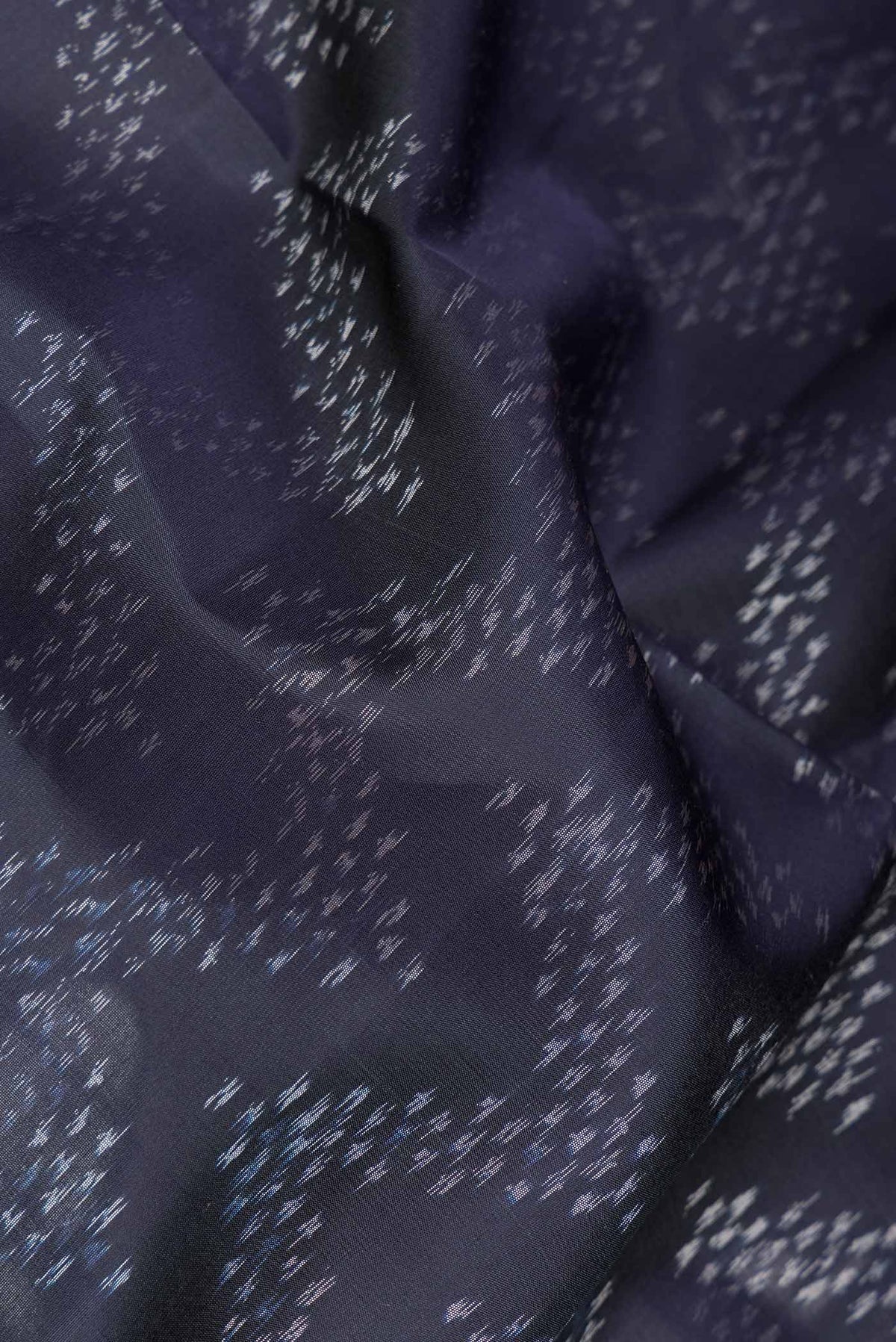 Close up of Navy Blue Dual Tone Soft Silk Saree with Ikat Print on the body and Ikat Border.  displaying folds