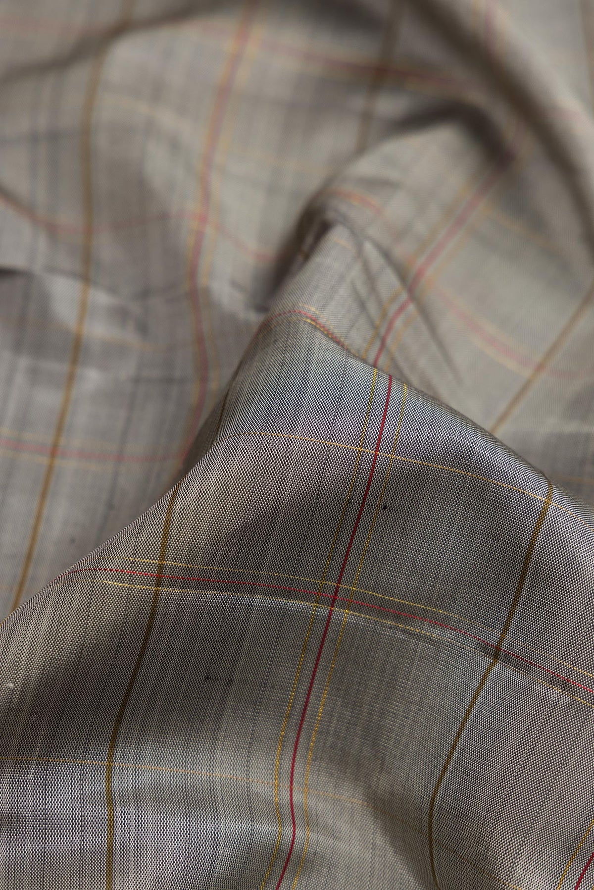 Close up of Pure Silk Pure Zari Grey Dual Tone Kanchipuram Saree with Checked design on the body and Zari Border.  displaying folds