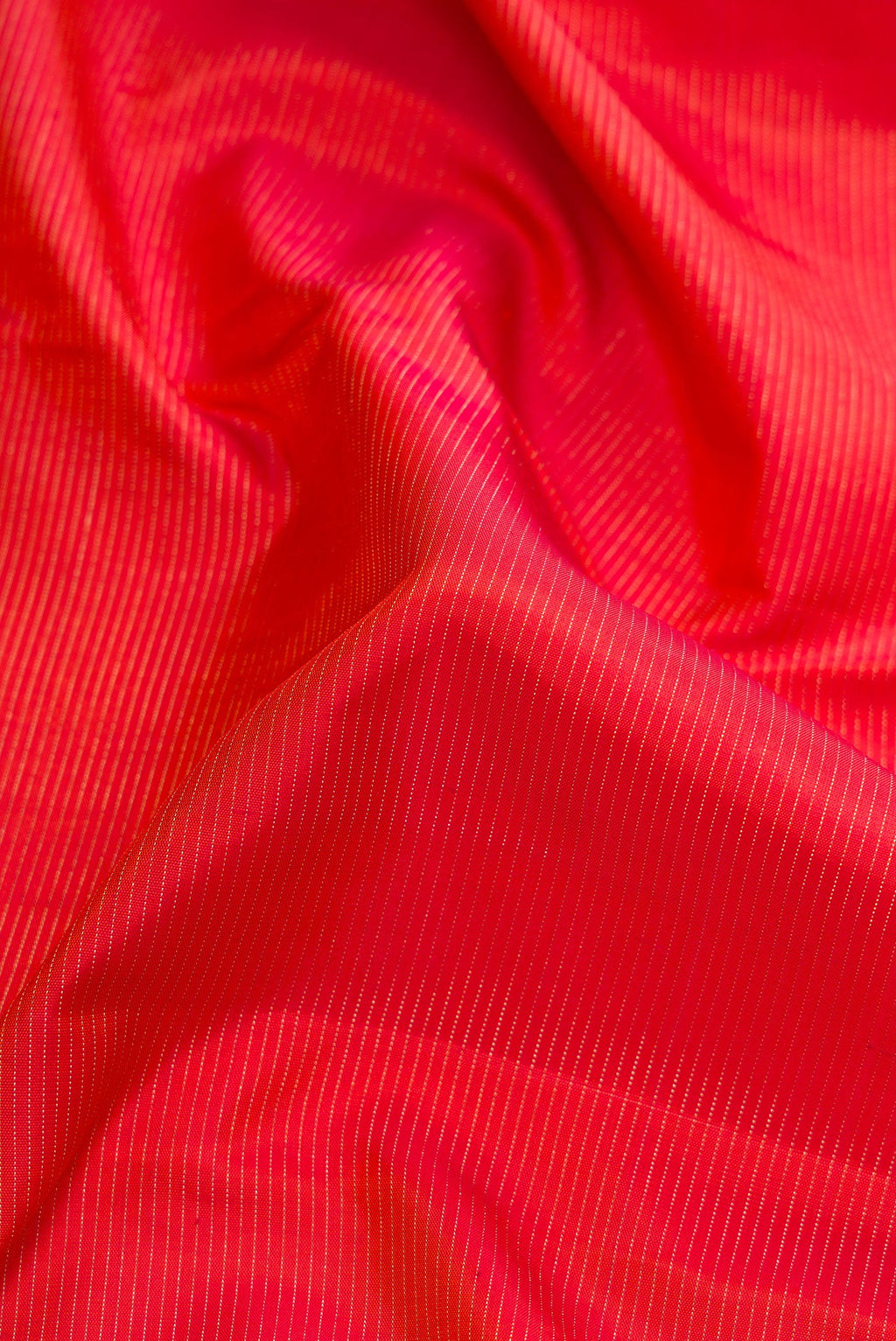 Close up of Brick Orange Dual Tone Kanjivaram Silk Saree with Stripes on the body and Checks Border.  displaying folds
