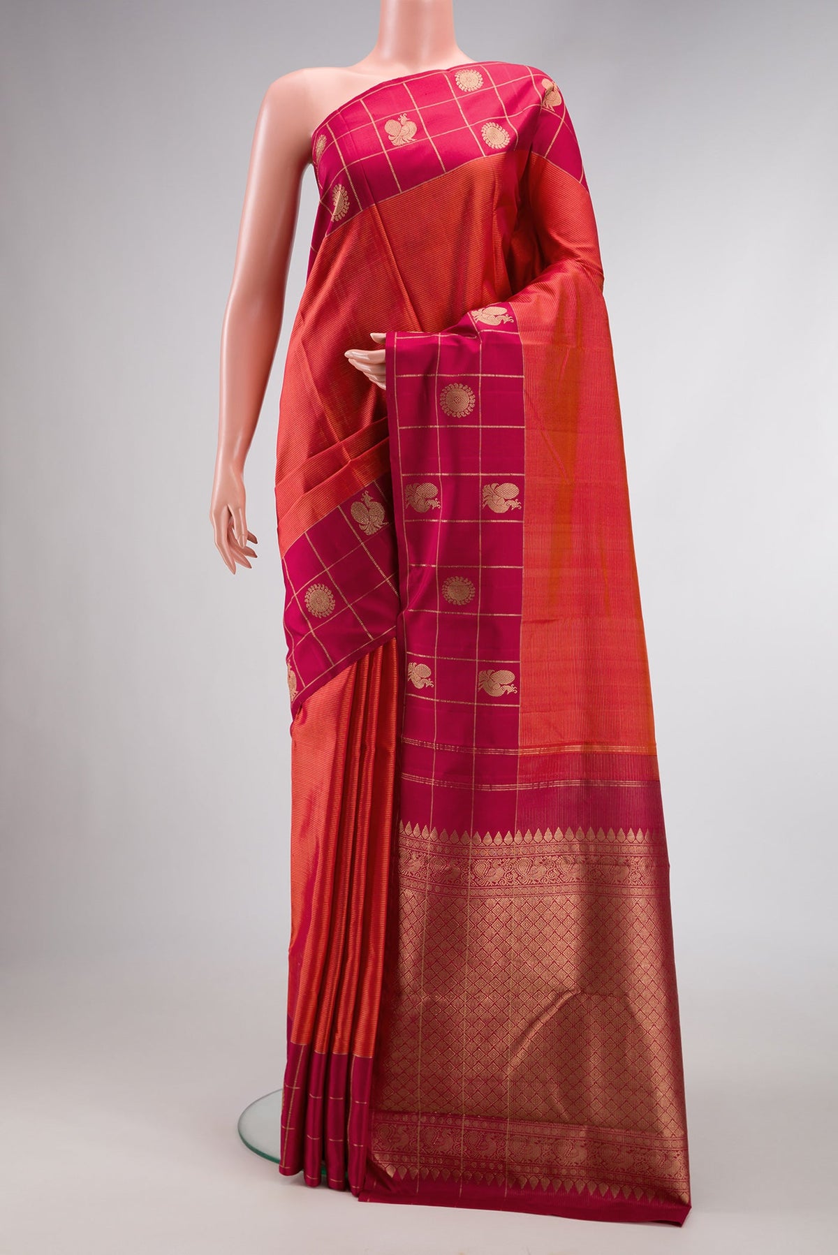 Brick Orange Dual Tone Kanjivaram Silk Saree with Stripes on the body and Checks Border.  displayed on a mannequin