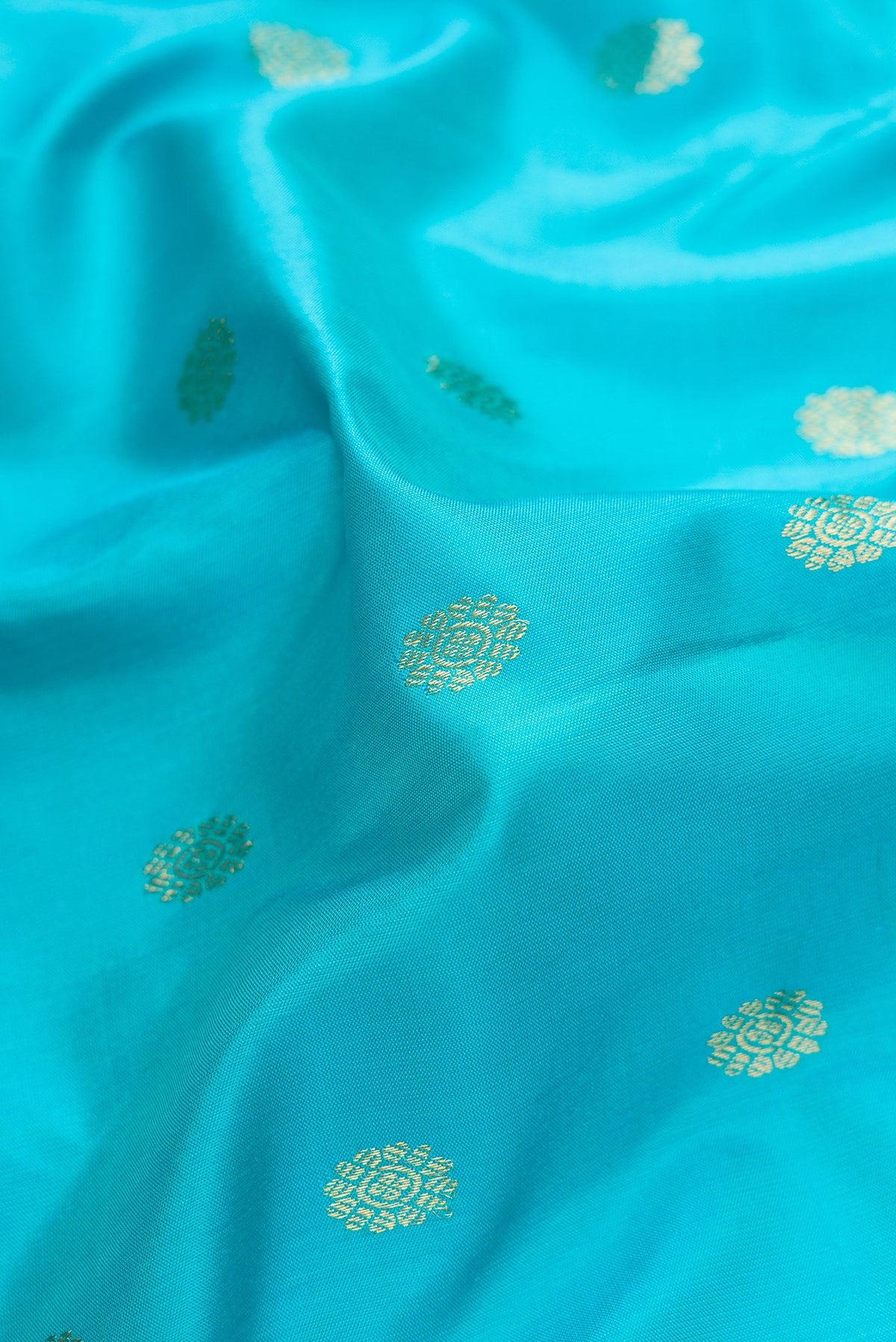 Close up of Sky Blue Dual Tone Gadwal Silk Saree with Zari Butta on the body and Temple Border.  displaying folds
