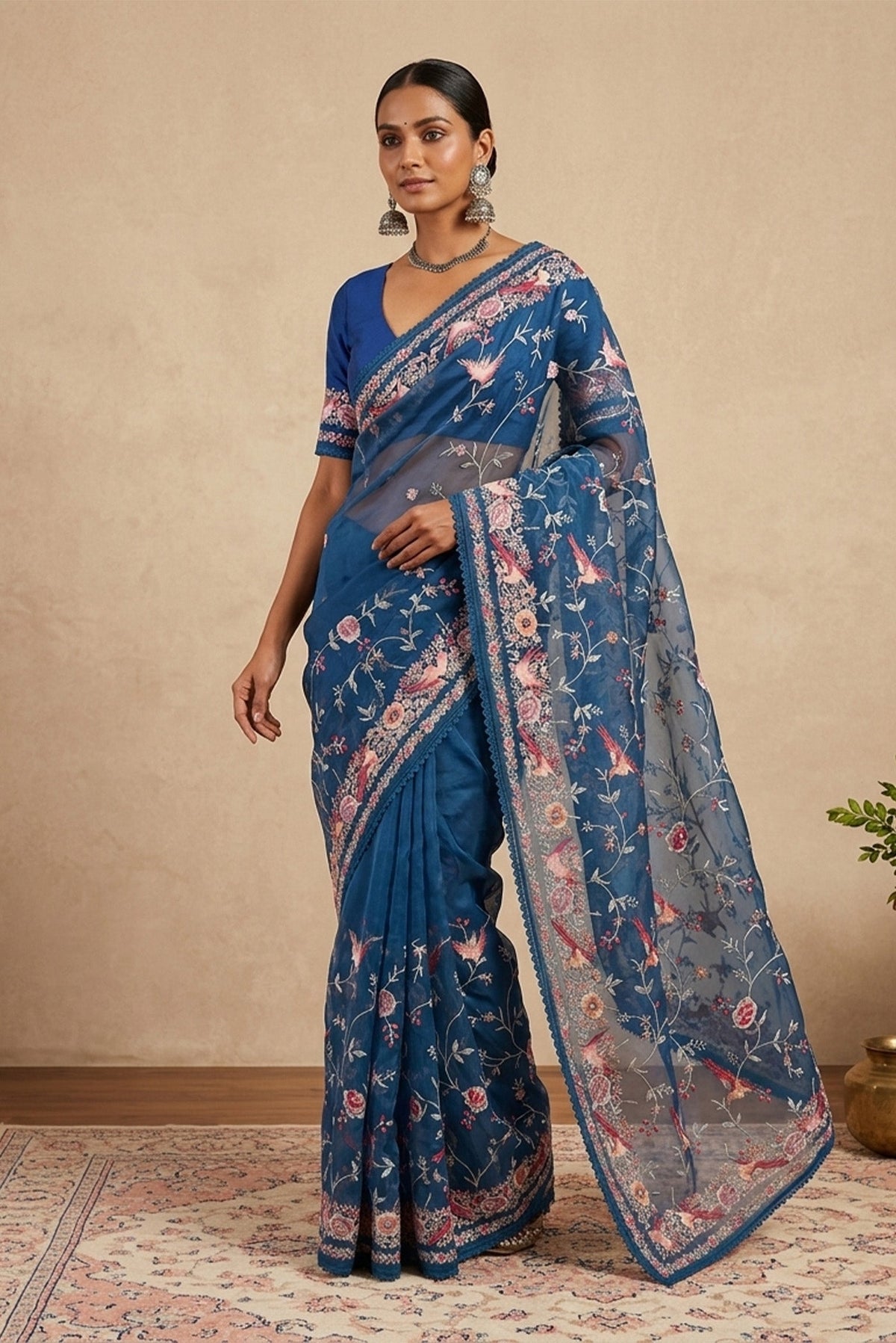 Model wearing a Maya Blue Organza Silk Saree with Embroidery on the body and Embroidery Border.