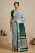 Model wearing a Blue Grey Uppada Silk Saree with Zari Butta on the body and Zari Border.