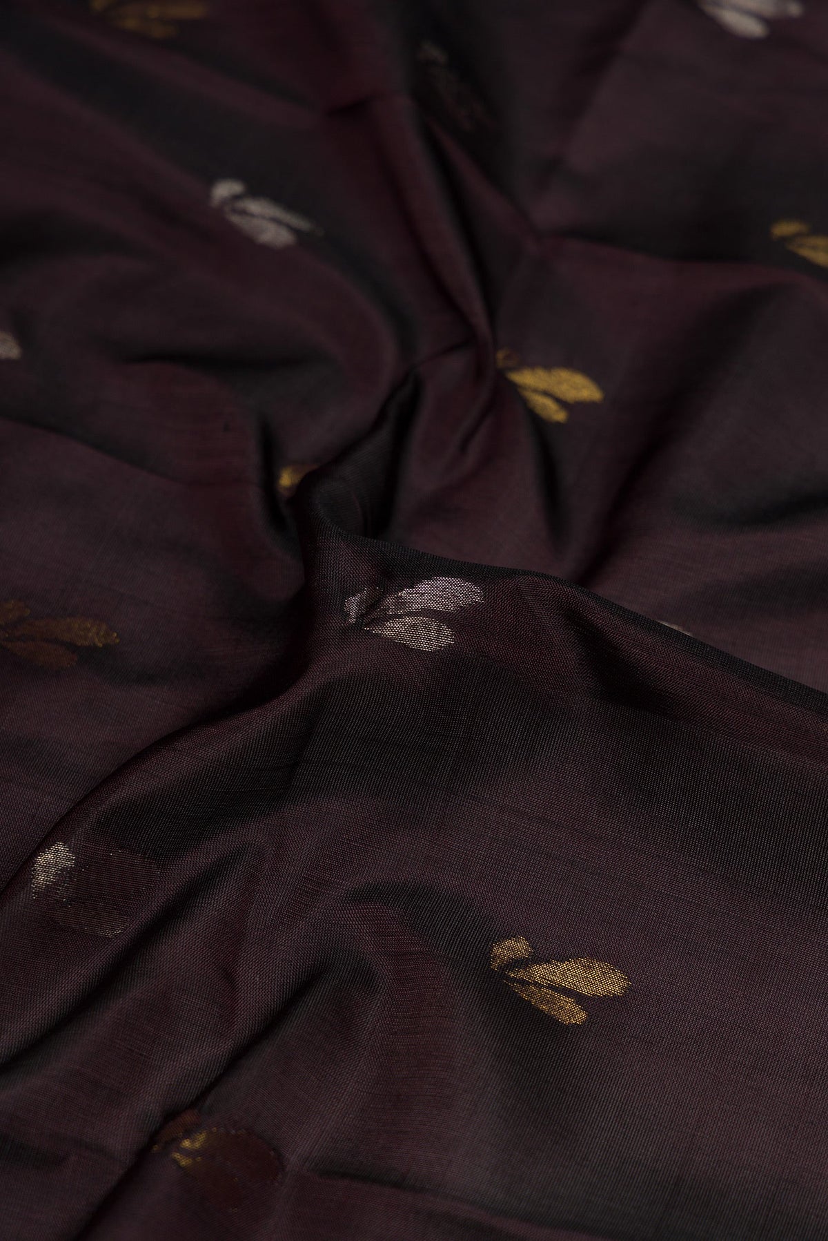 Close up of Coffee Brown Dual Tone Soft Silk Saree with Zari Butta on the body and Zari Border.  displaying folds