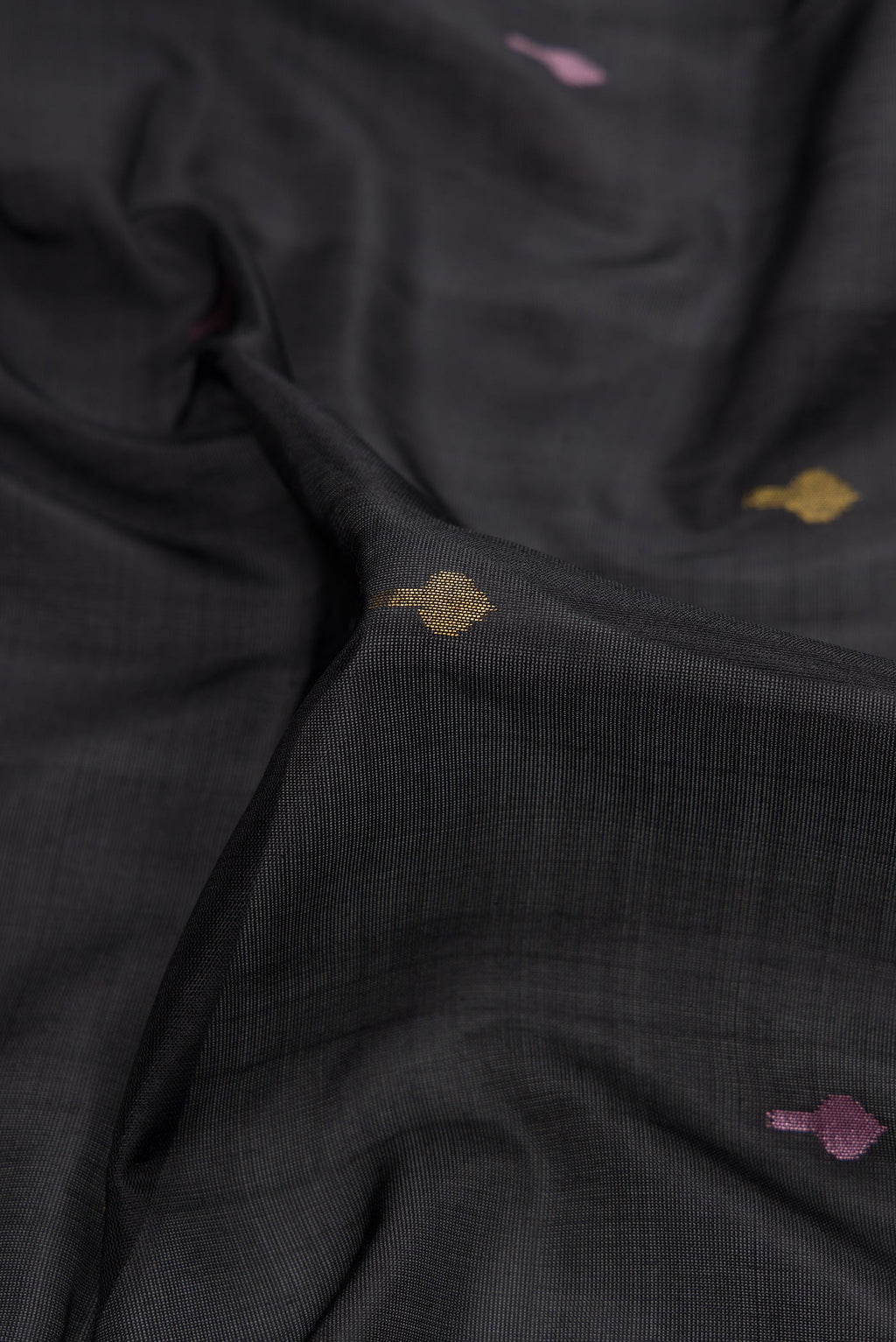 Close up of Black Dual Tone Uppada Silk Saree with Zari And Thread Butta on the body and Zari Border.  displaying folds