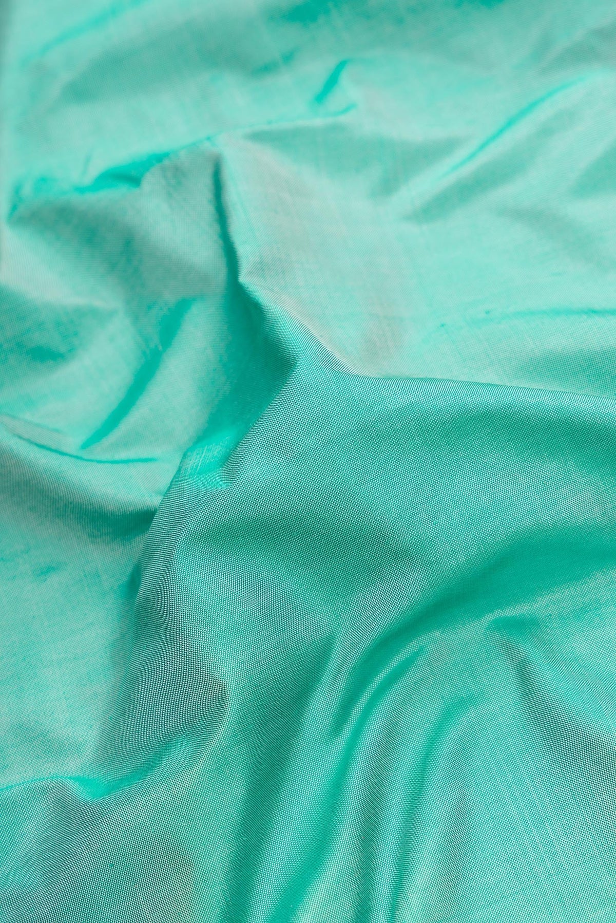 Close up of Green Dual Tone Double Ikat Saree with Plain Body and Temple Border.  displaying folds