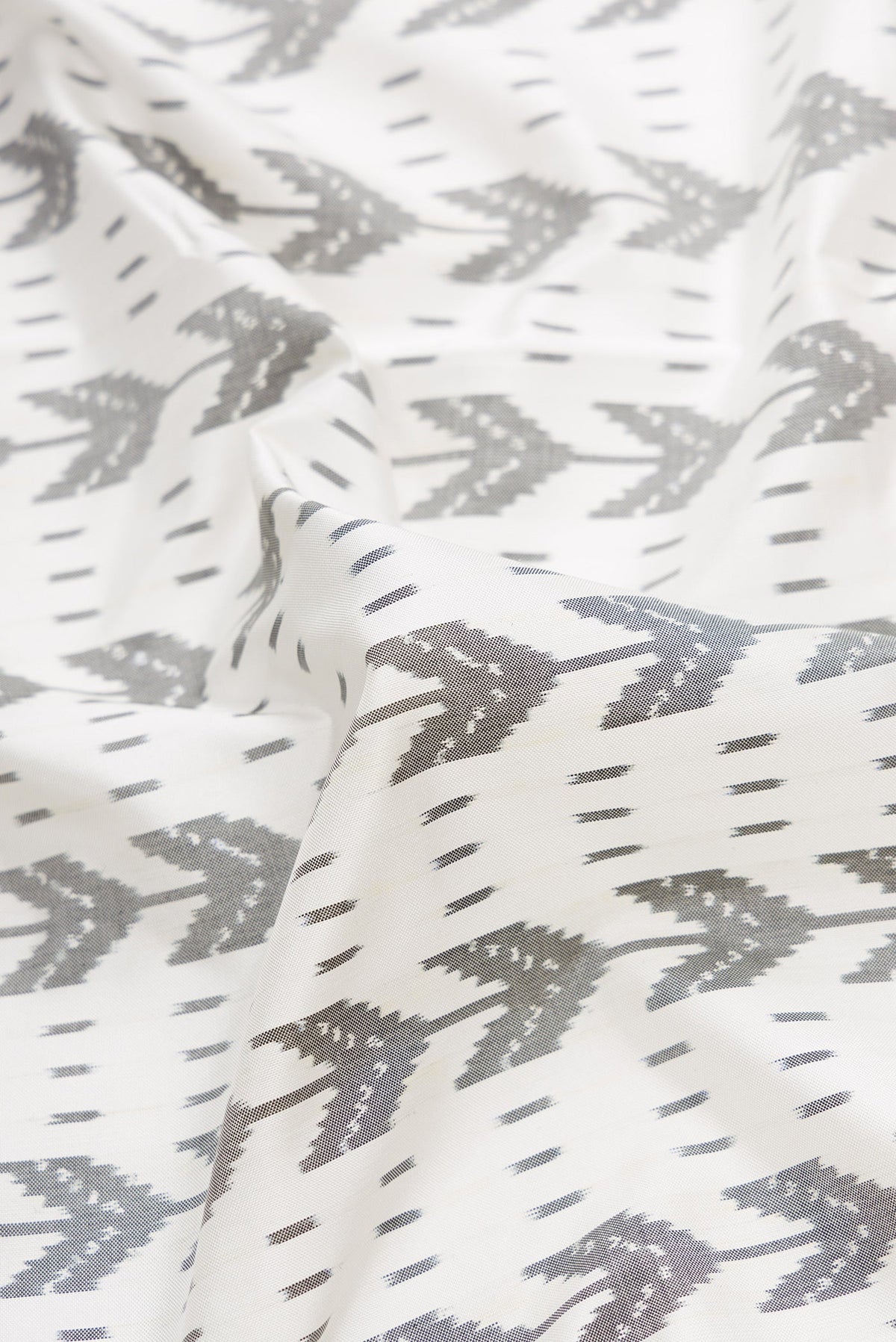 Close up of Off White Dual Tone Double Ikat Saree with Ikat Print on the body and Zari Border.  displaying folds