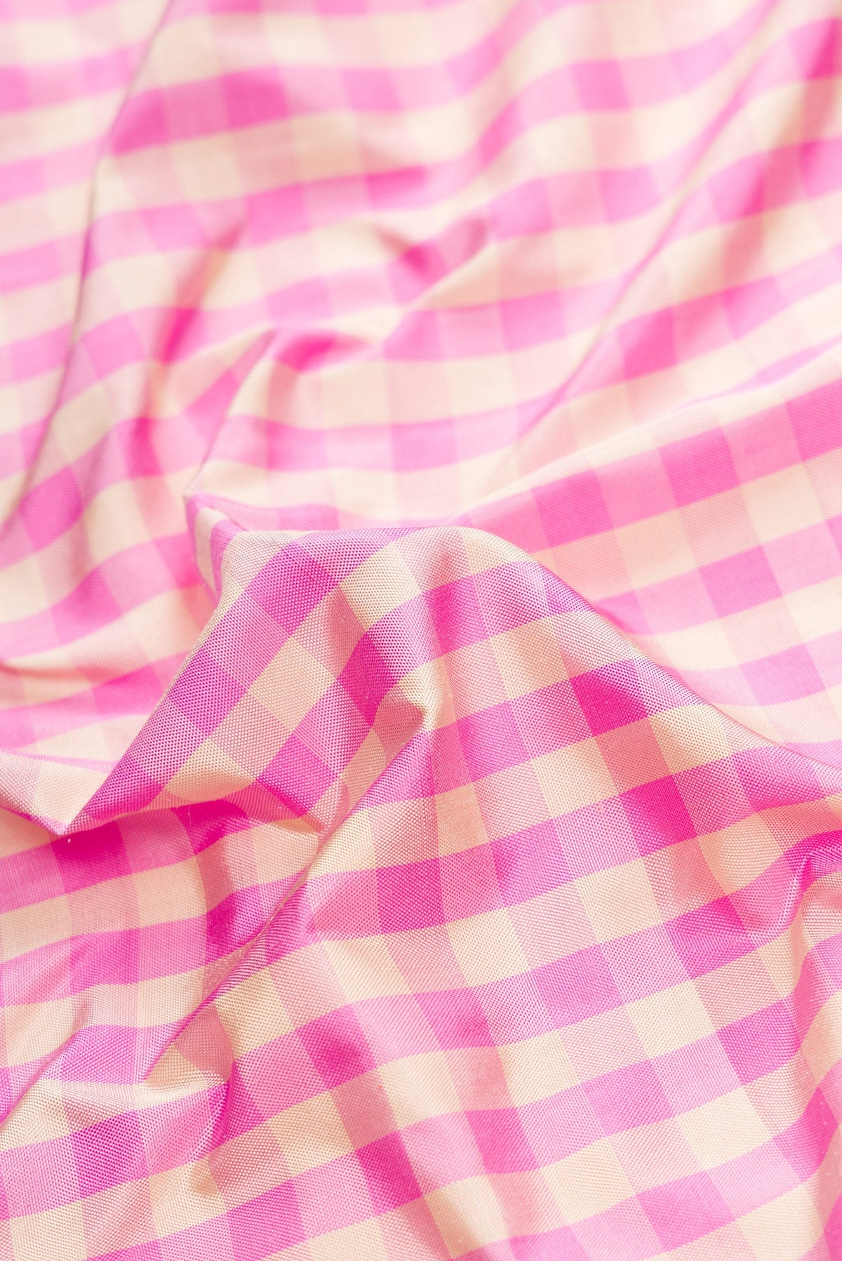 Close up of Pure Silk Pure Zari Pink Dual Tone Double Ikat Saree with Checked design on the body and Thread Border.  displaying folds