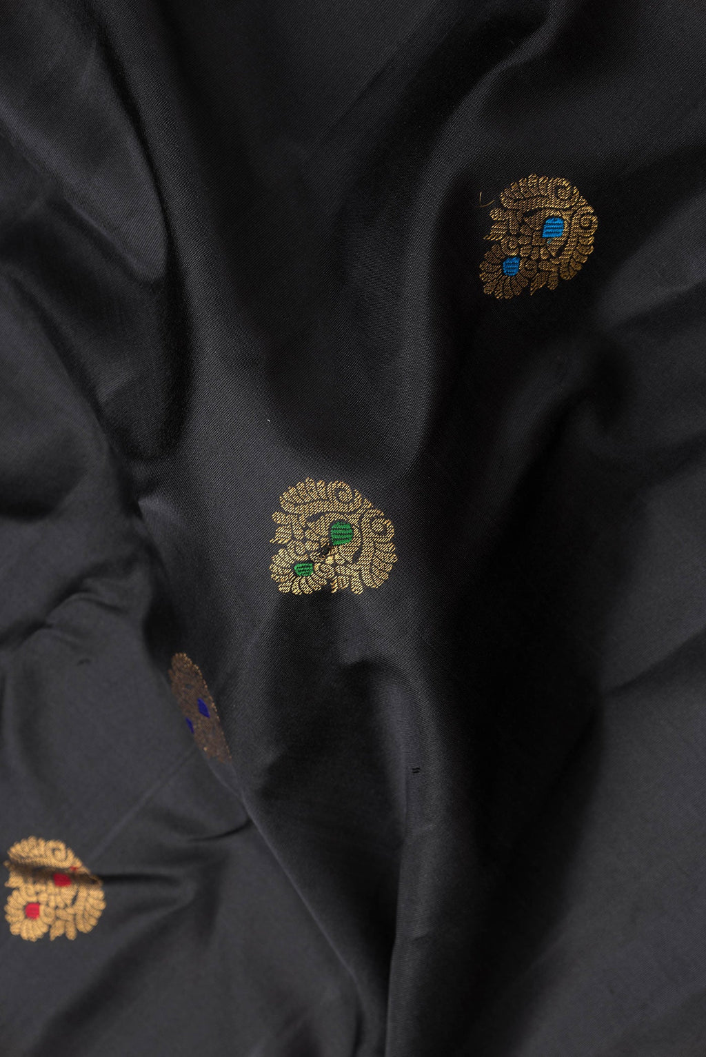 Close up of Black Dual Tone Gadwal Silk Saree with Zari And Thread Butta on the body and Zari Border.  displaying folds