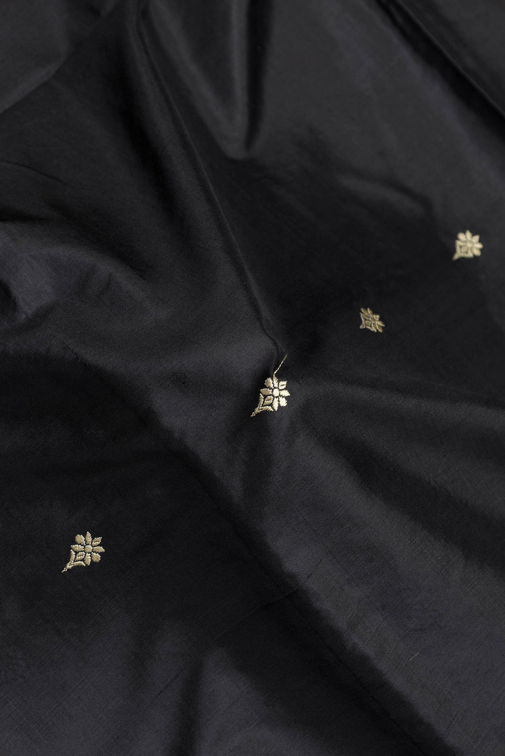 Close up of Black Dual Tone Banarasi Silk Saree with Thread Butta on the body and Thread Border.  displaying folds