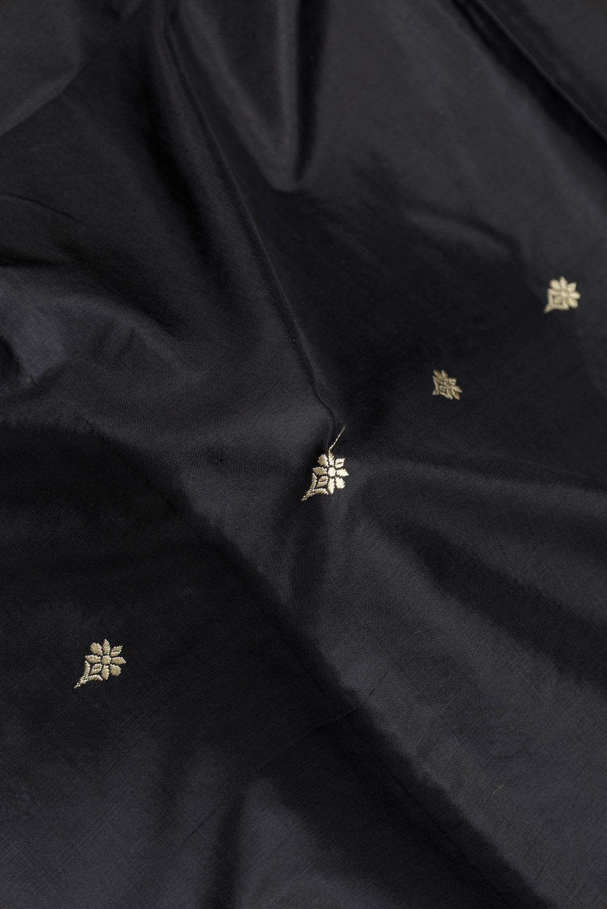 Close up of Black Dual Tone Banarasi Silk Saree with Thread Butta on the body and Thread Border.  displaying folds