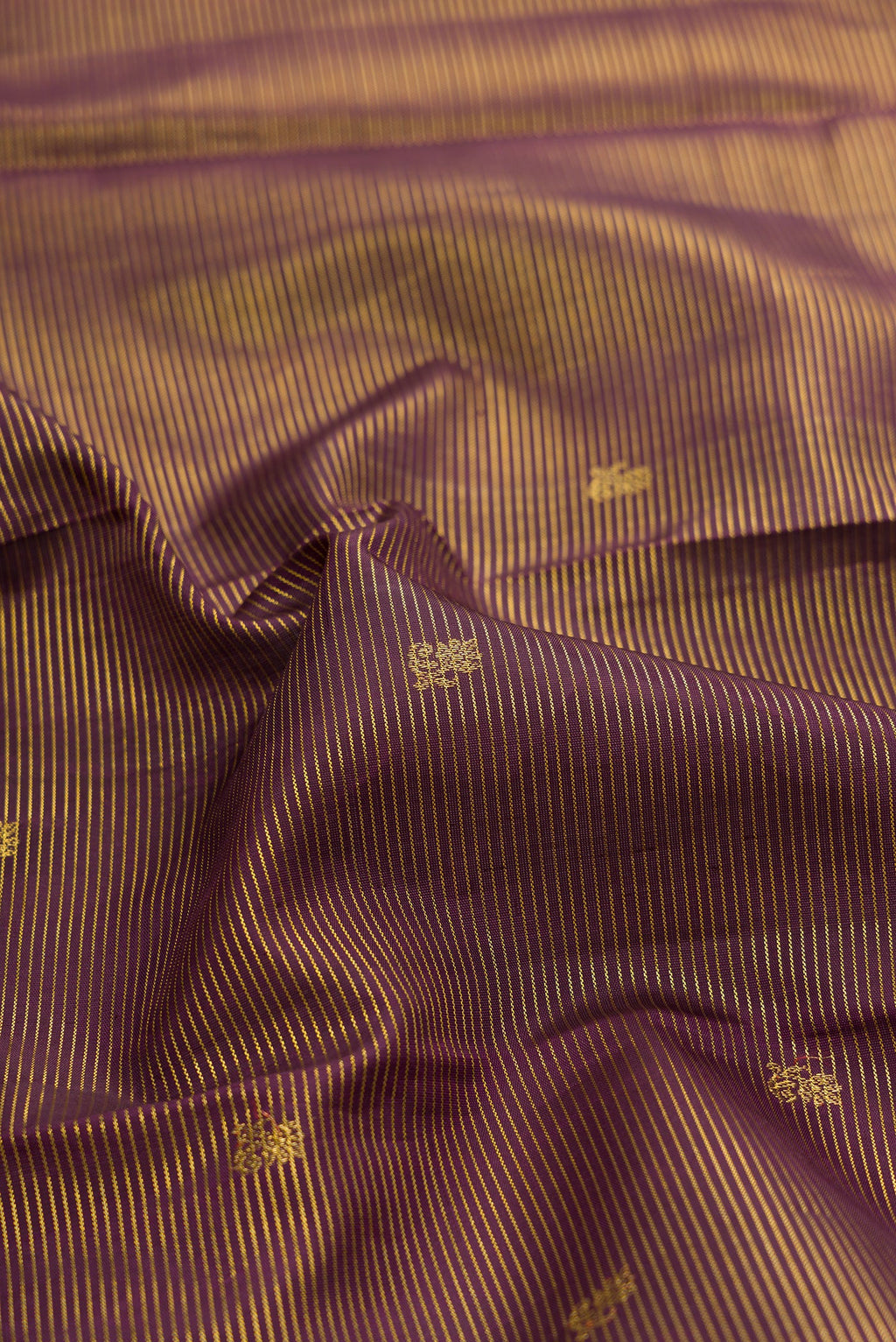 Close up of Coffee Brown Kanchipuram Silk Saree with Zari Butta on the body and Zari Border.  displaying folds