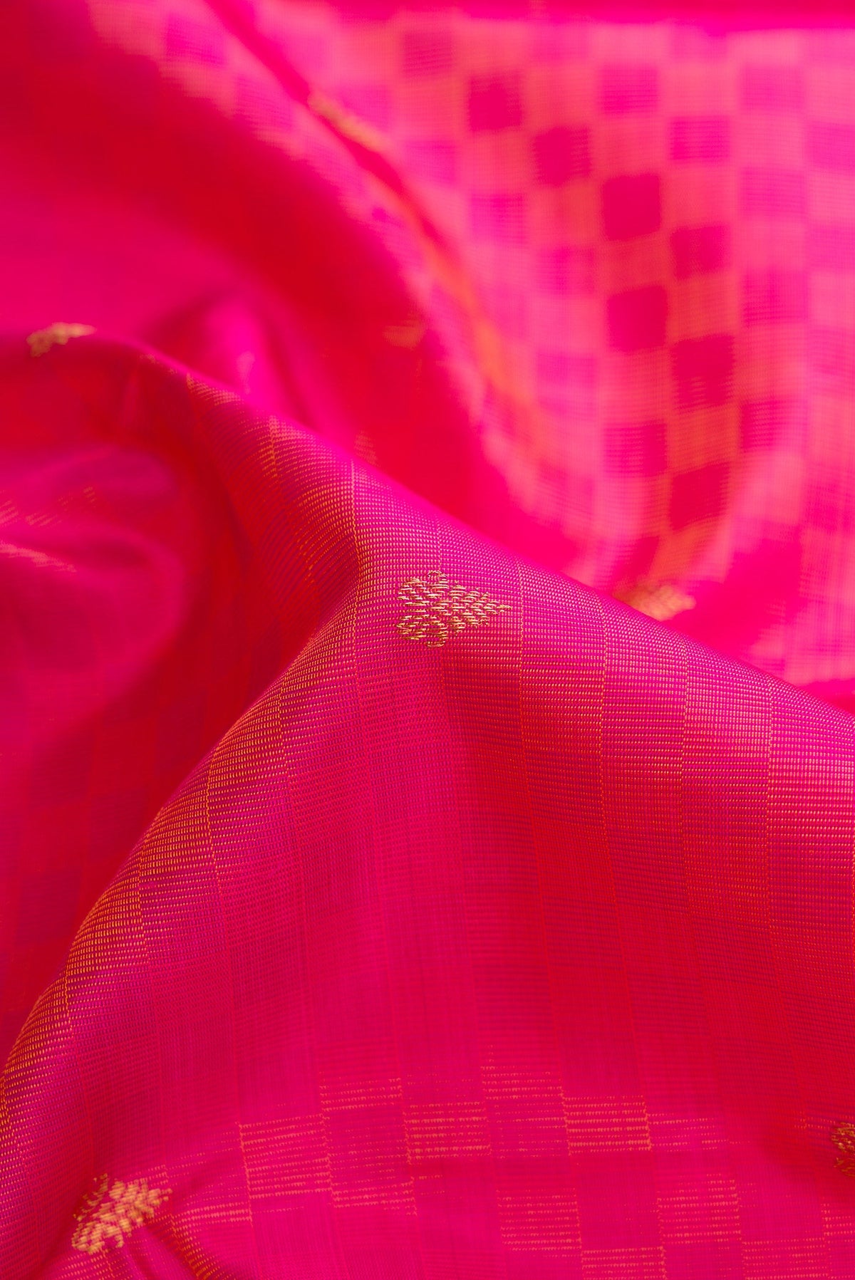 Close up of Pure Silk Pure Zari Peach Dual Tone Kanchipuram Saree with Zari Butta on the body and Fancy Border.  displaying folds
