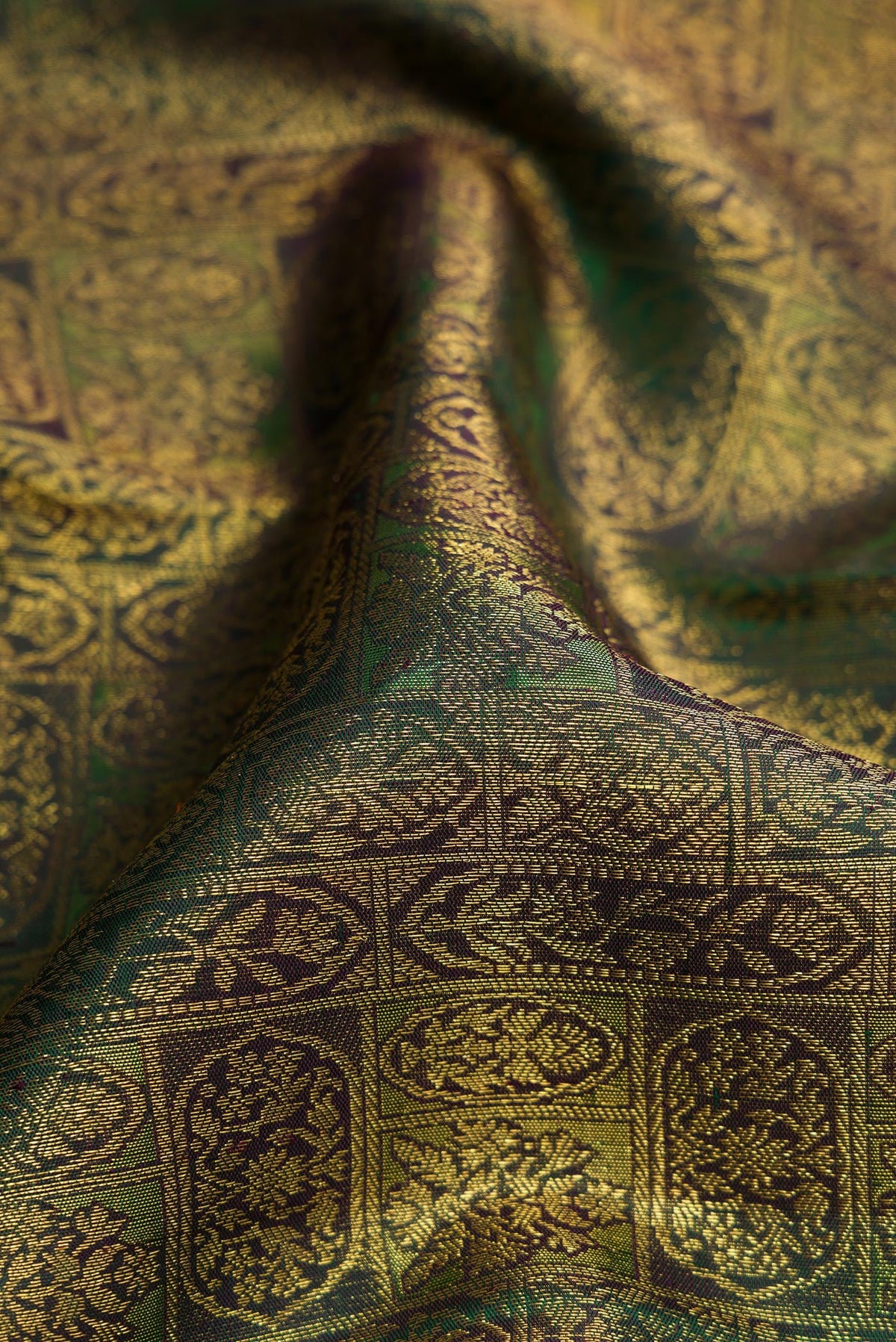 Close up of Green Dual Tone Kanchipuram Silk Saree with Zari Brocade on the body and Zari Border.  displaying folds