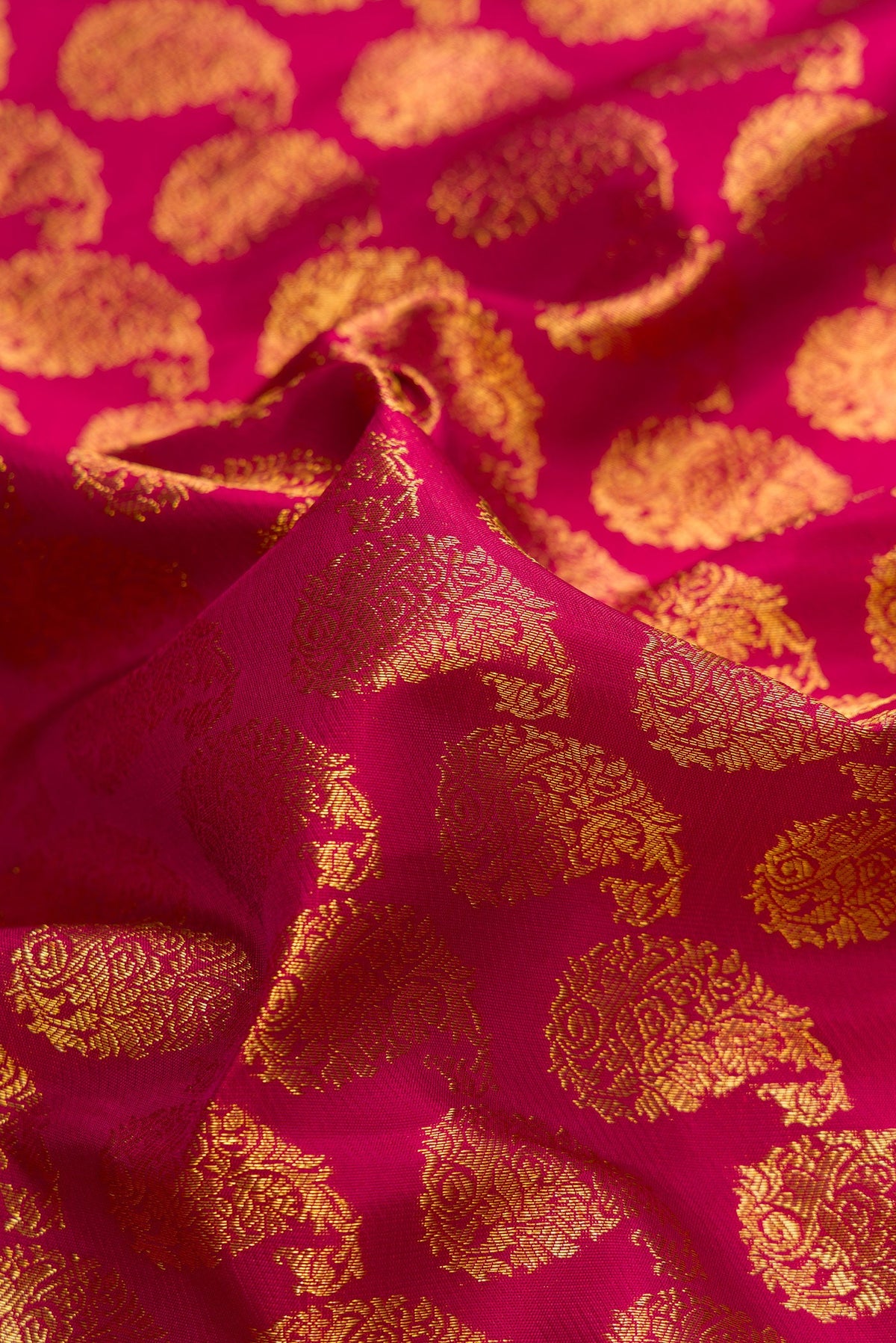 Close up of Maroon Dual Tone Kanjivaram Silk Saree with Zari Brocade on the body and Zari Border.  displaying folds