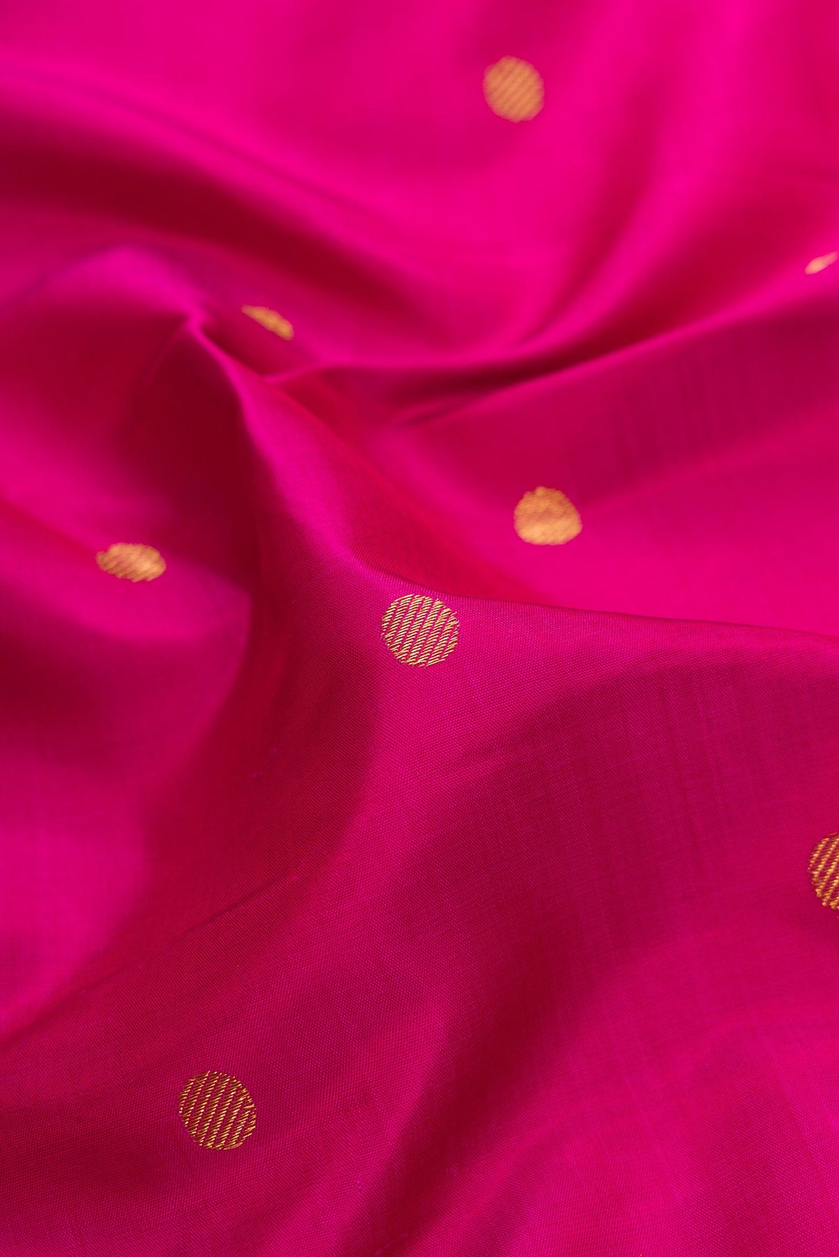 Close up of Pure Silk Pure Zari Magenta Dual Tone Kanchipuram Saree with Zari Butta on the body and Fancy Border.  displaying folds