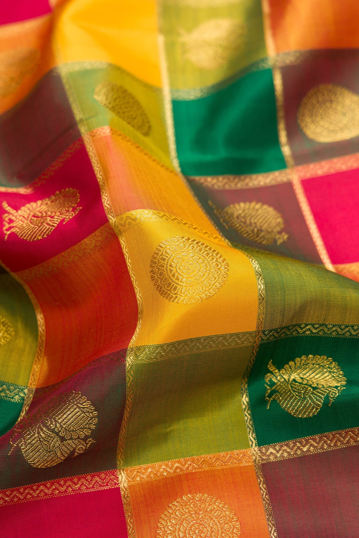 Close up of Pure Silk Pure Zari Yellow, Maroon and Green Color Kanjivaram Saree with Checked design on the body and Zari Border.  displaying folds