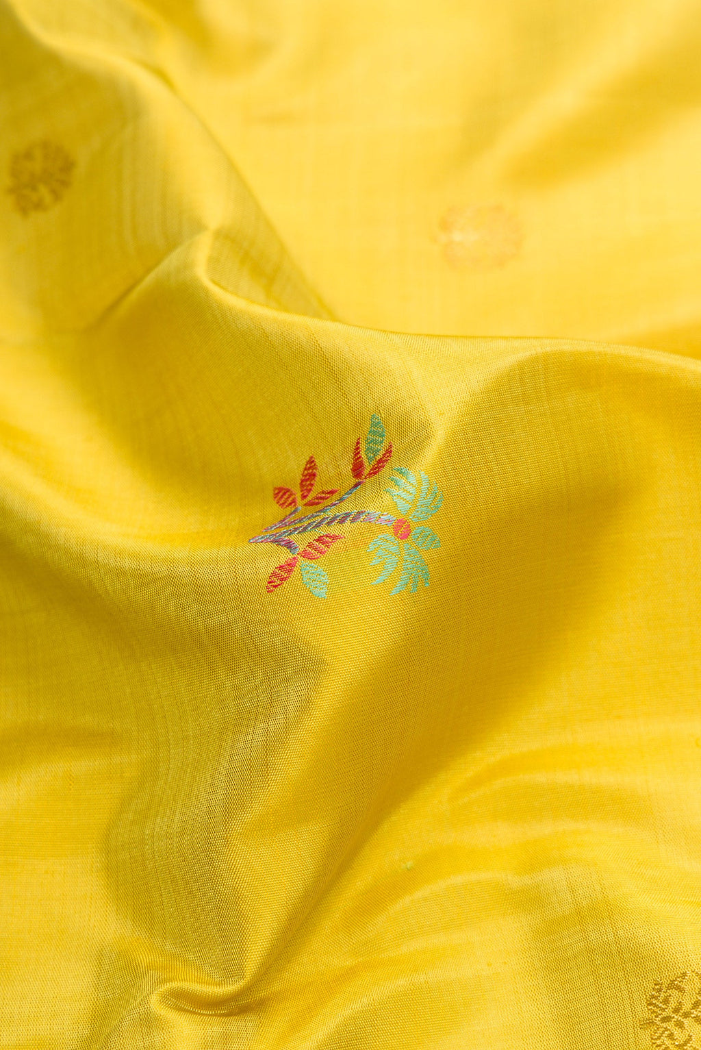 Close up of Pure Silk Pure Zari Lemon Yellow Dual Tone Kanchipuram Saree with Zari And Thread Butta on the body and Zari And Thread Border.  displaying folds