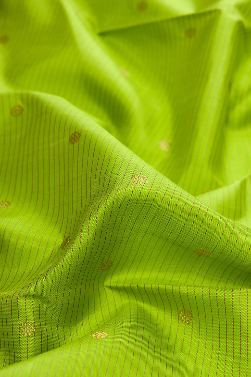 Close up of Pure Silk Pure Zari Parrot Green Dual Tone Kanchipuram Saree with Stripes on the body and Zari Border.  displaying folds