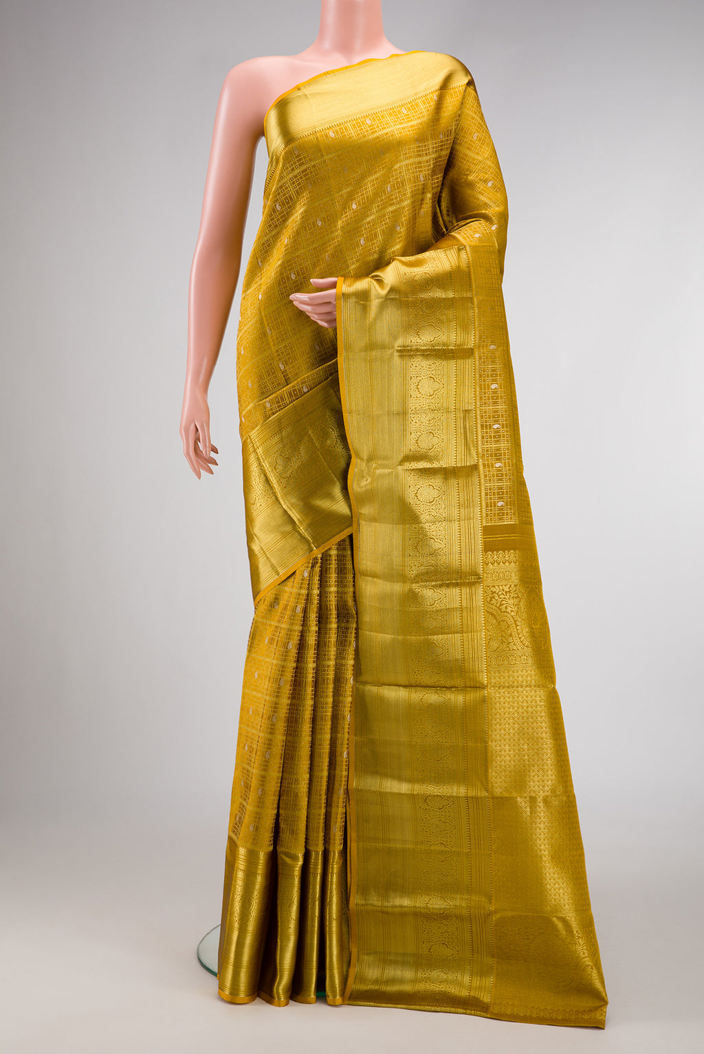 Mustard Kanchipuram Silk Saree with Zari Brocade on the body and Zari Border.  displayed on a mannequin