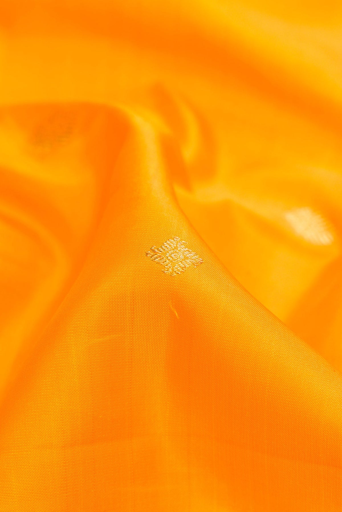 Close up of Pure Silk Pure Zari Yellow Dual Tone Kanjivaram Saree with Zari Butta on the body and Zari Border.  displaying folds