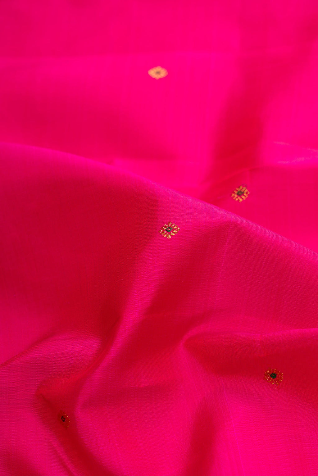 Close up of Dark Pink Dual Tone Kanchipuram Silk Saree with Zari Butta on the body and Zari Border.  displaying folds