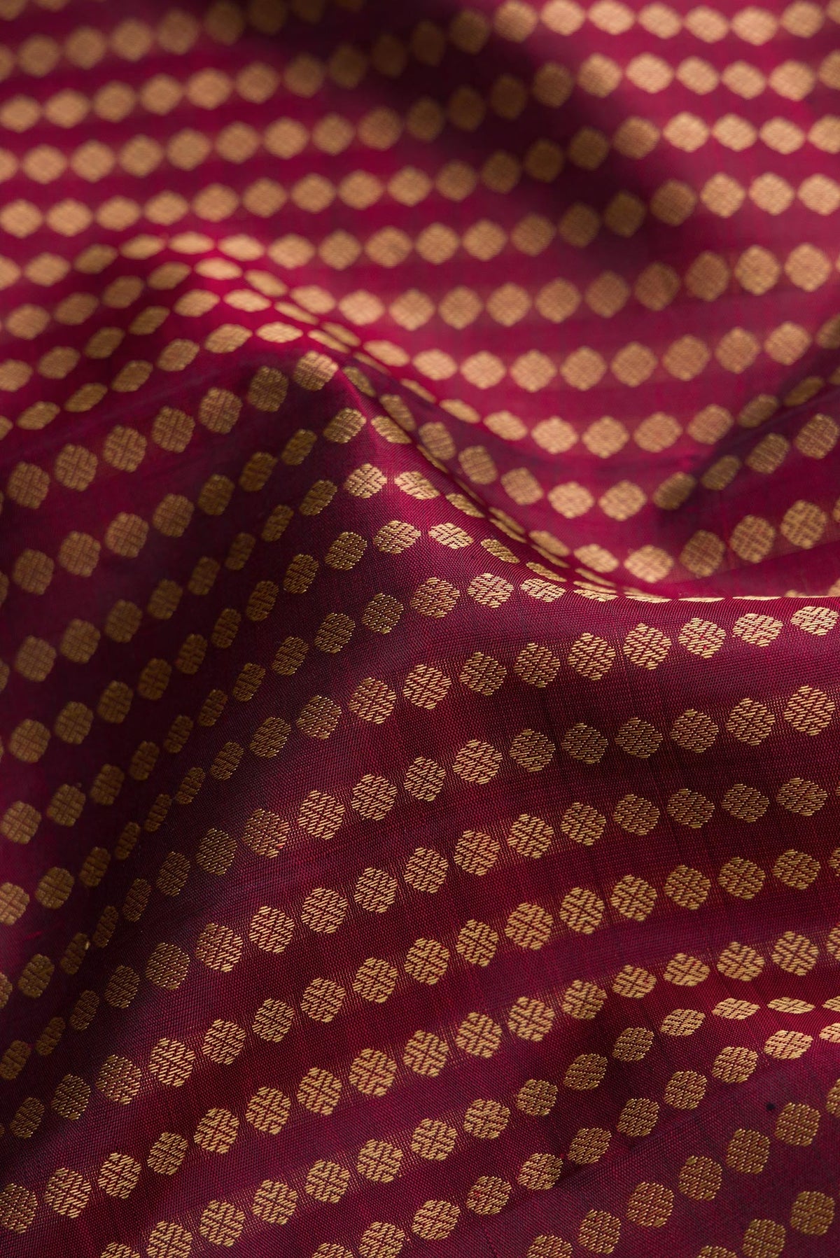 Close up of Burgundy Dual Tone Kanjivaram Silk Saree with Zari Butta on the body and Fancy Border.  displaying folds