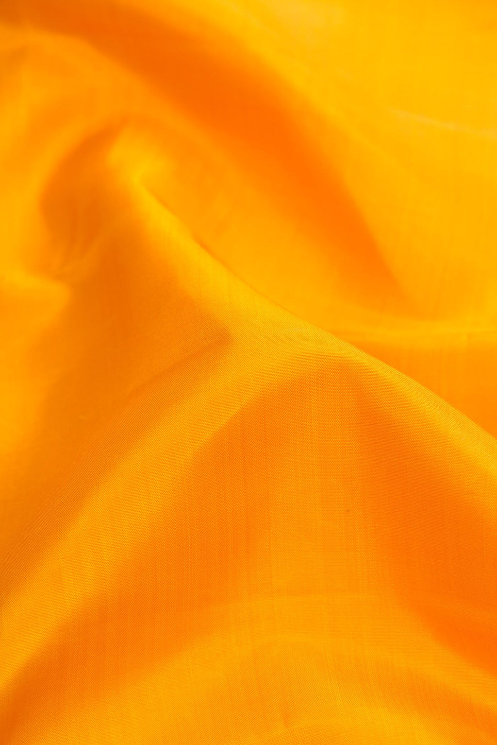 Close up of Pure Silk Pure Zari Yellow Dual Tone Kanjivaram Saree with Plain Body and Zari Border.  displaying folds