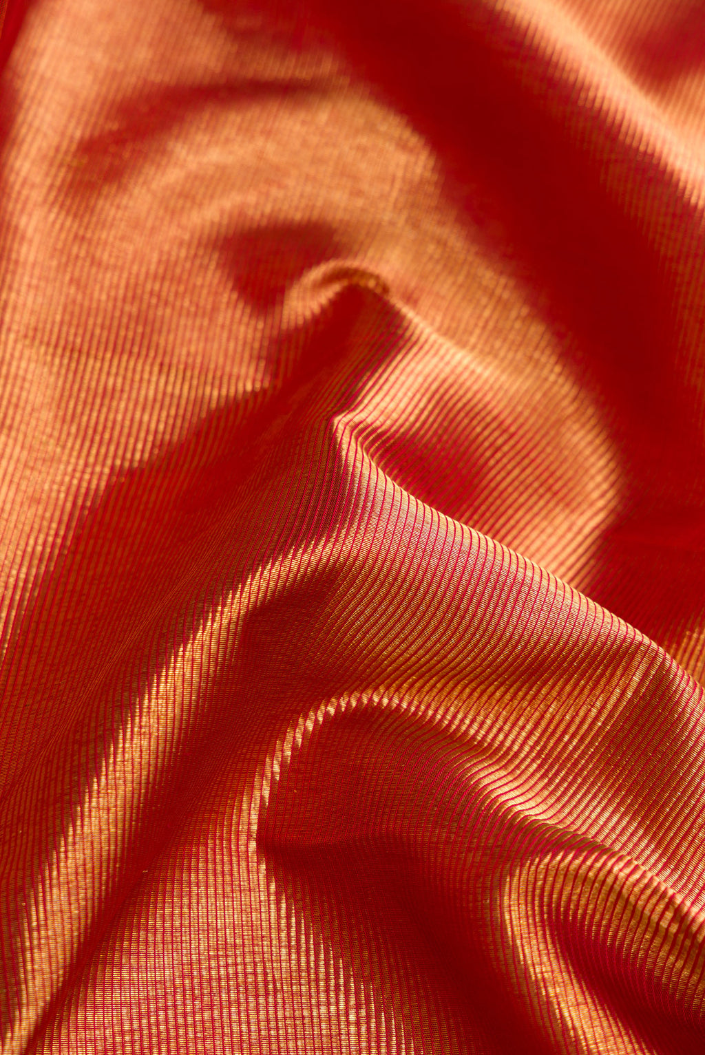 Close up of Gold with Red Color Kanjivaram Silk Saree with Zari Brocade on the body and Fancy Border.  displaying folds