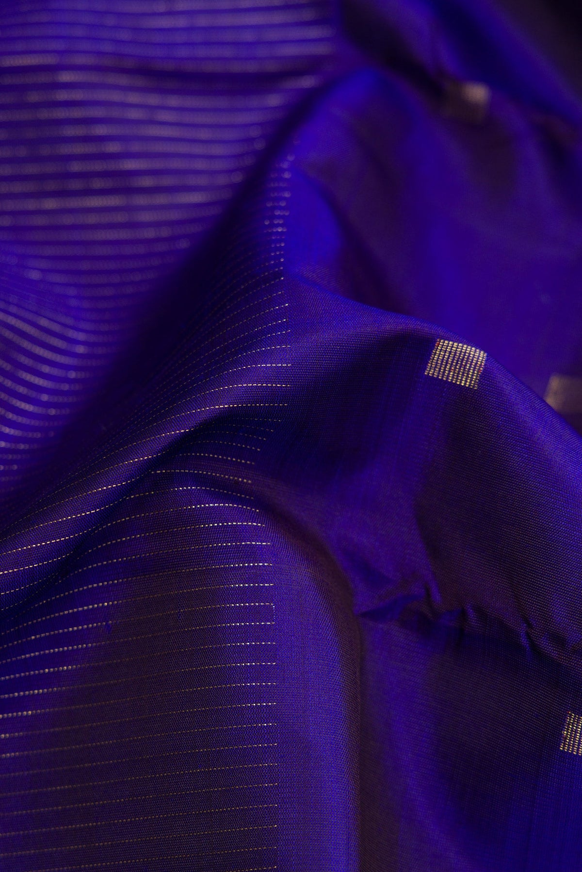 Close up of Pure Silk Pure Zari Royal Blue Dual Tone Kanchipuram Saree with Half And Half on the body and Without Border.  displaying folds