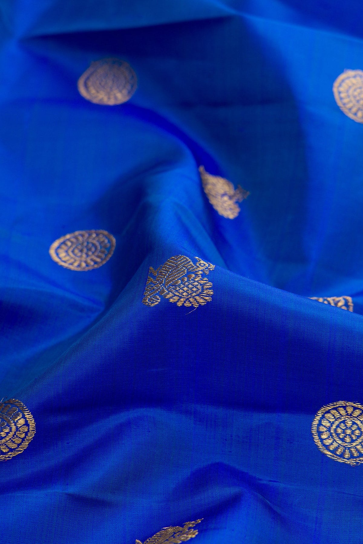 Close up of Pure Silk Pure Zari Royal Blue Dual Tone Kanjivaram Saree with Zari Butta on the body and Zari Border.  displaying folds