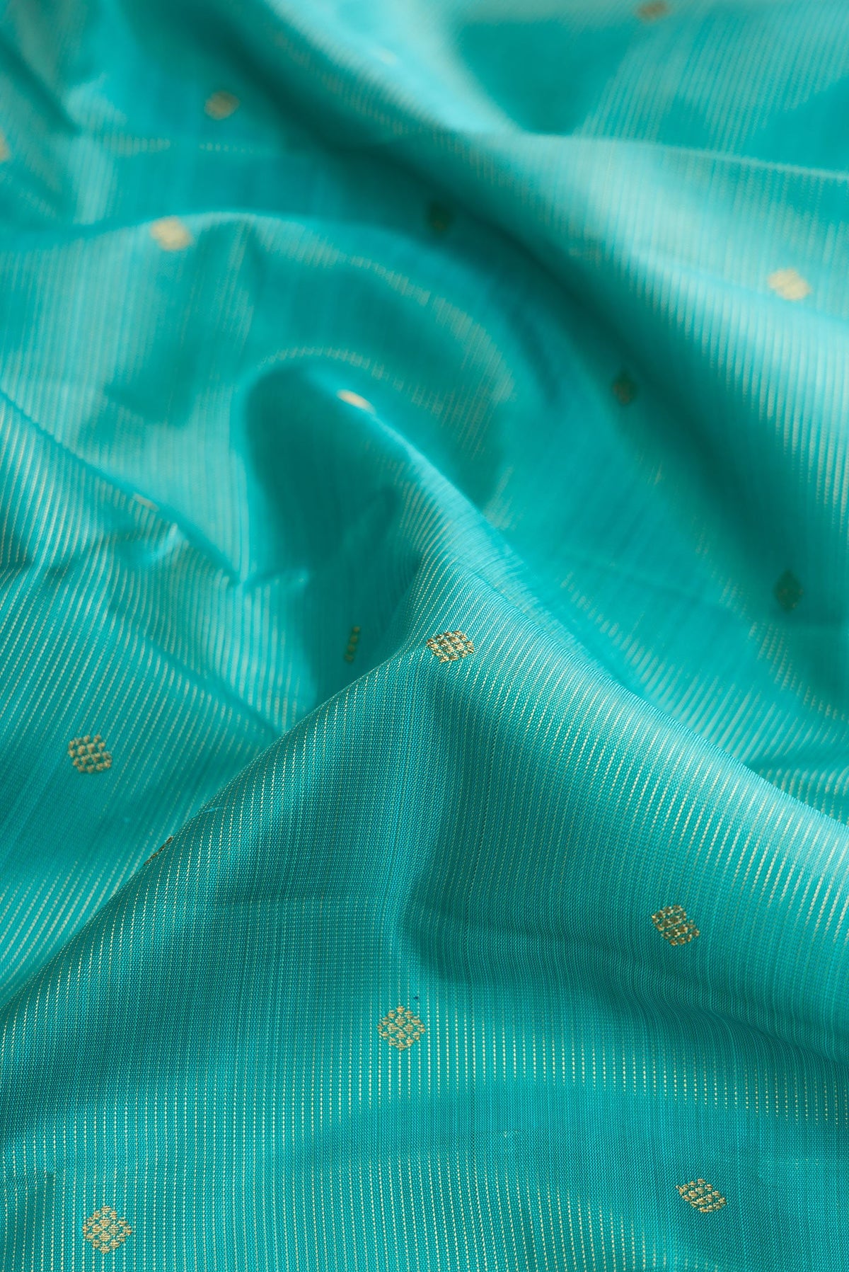 Close up of Pure Silk Pure Zari Light Blue Dual Tone Kanjivaram Saree with Stripes on the body and Zari Border.  displaying folds