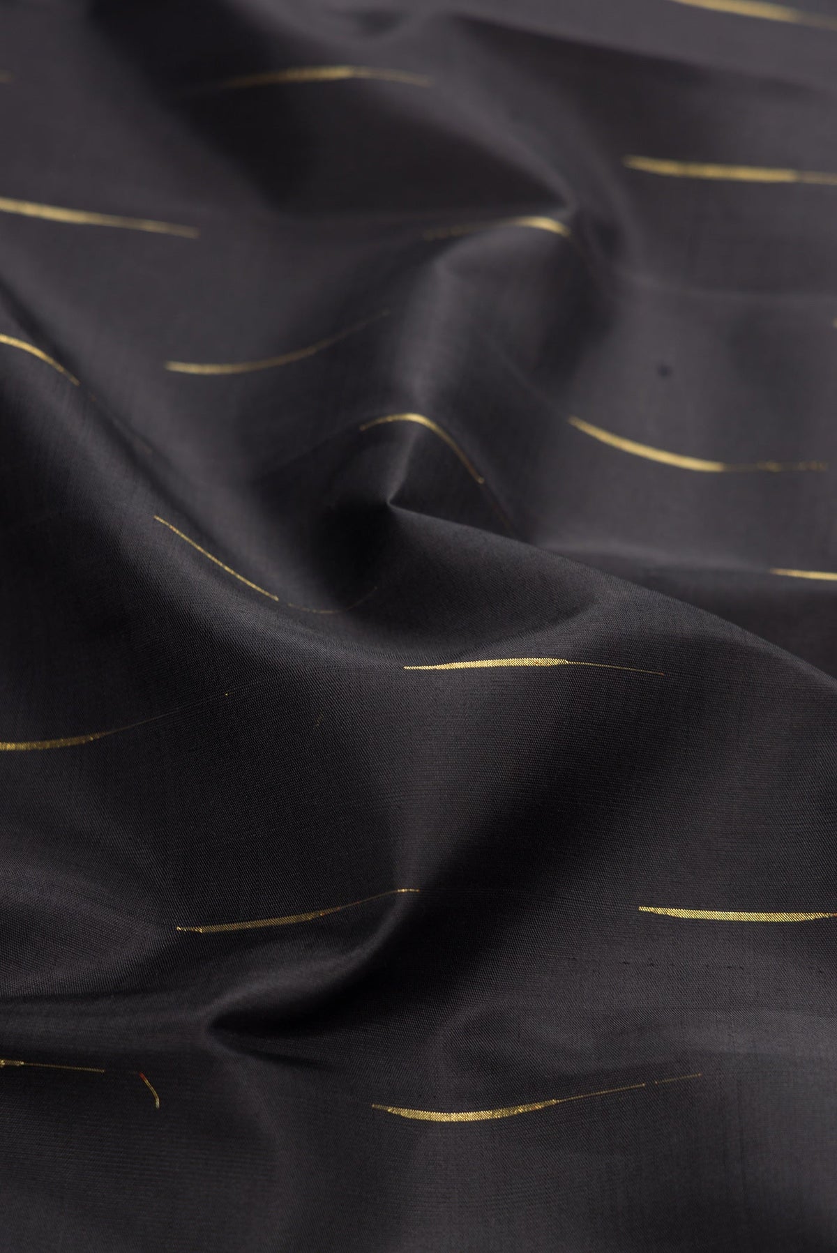 Close up of Black Dual Tone Kanjivaram Silk Saree with Zari Butta on the body and Zari Border.  displaying folds
