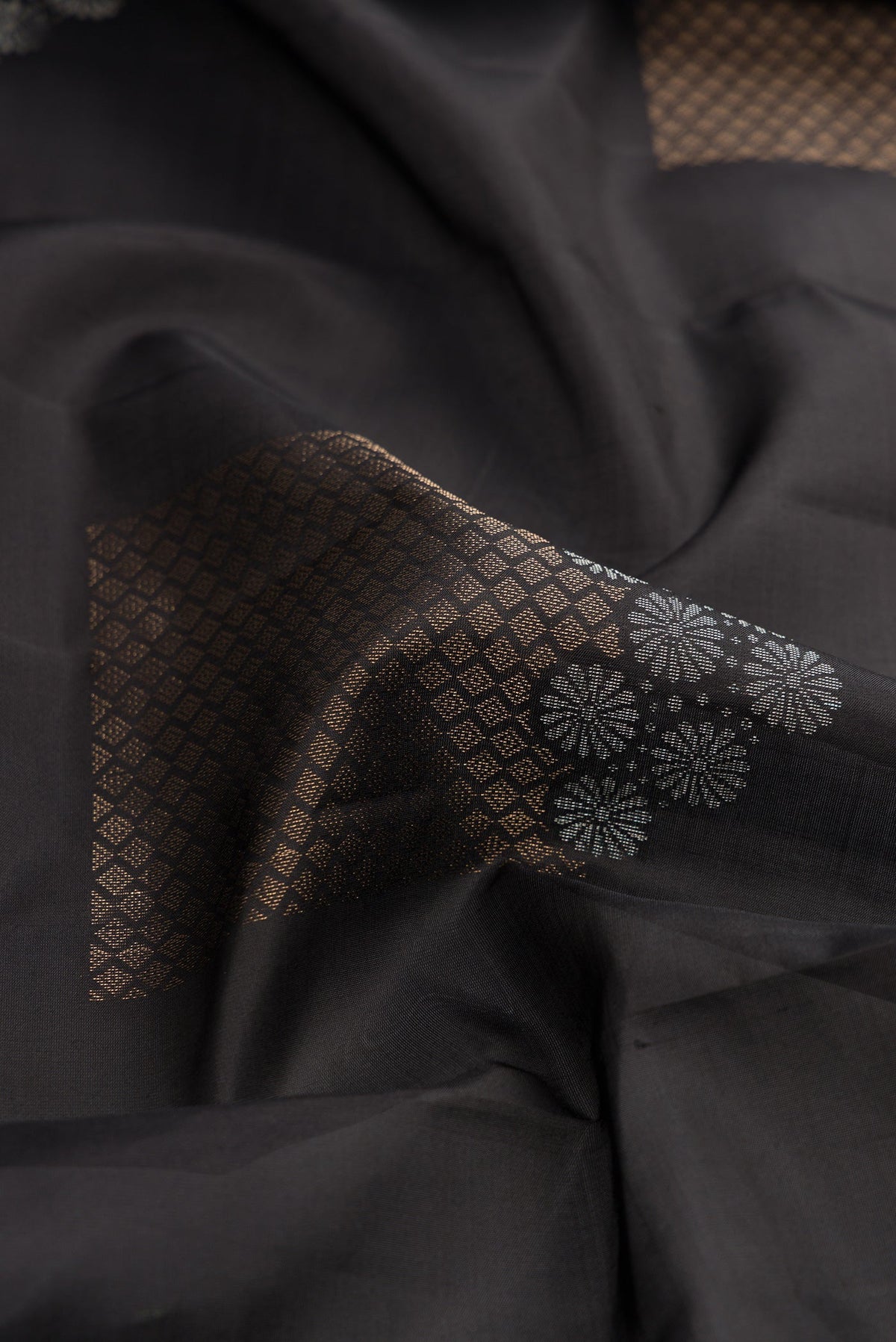 Close up of Black Dual Tone Soft Silk Saree with Zari Butta on the body and Without Border.  displaying folds
