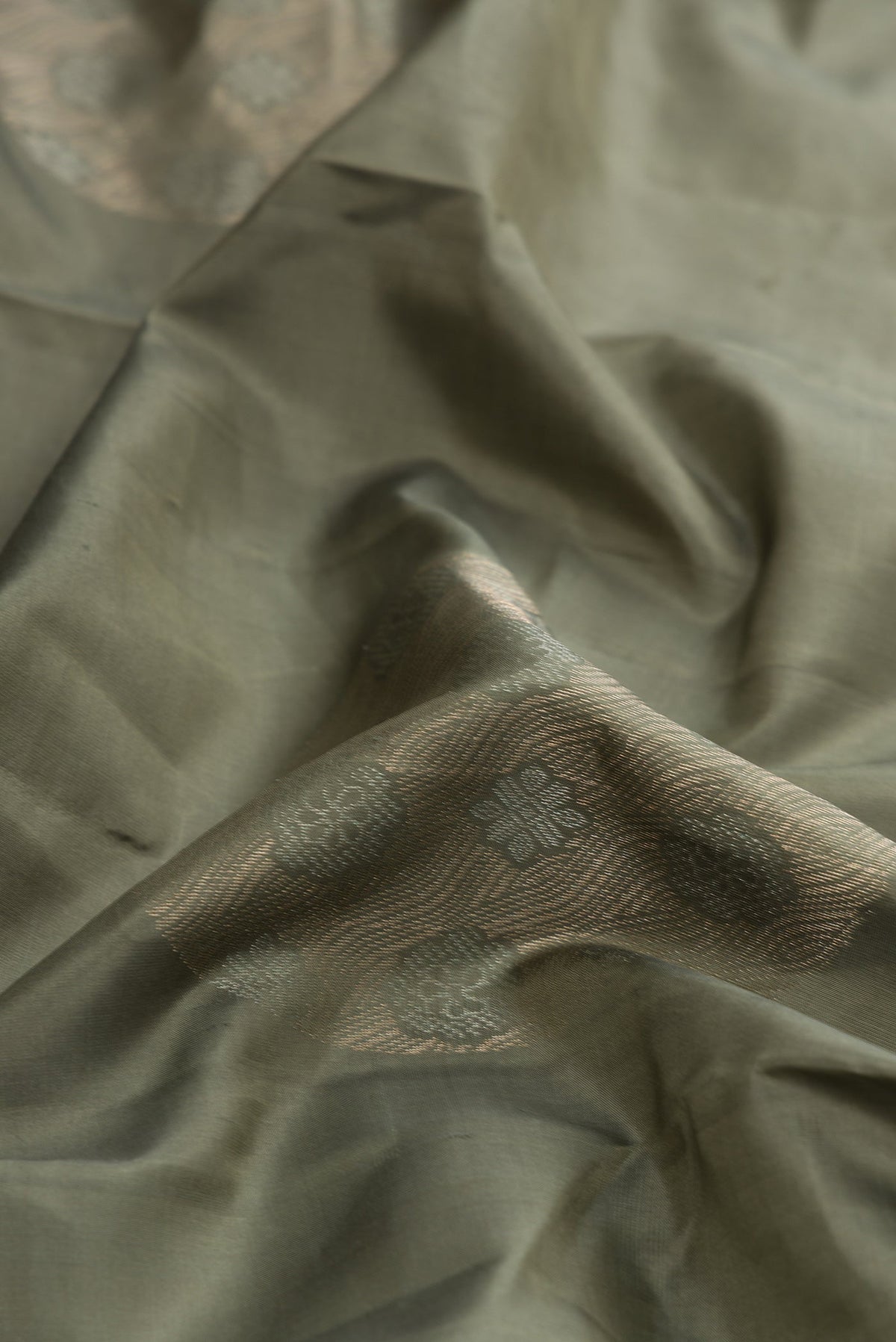 Close up of Brown Dual Tone Soft Silk Saree with Zari Butta on the body and Without Border.  displaying folds
